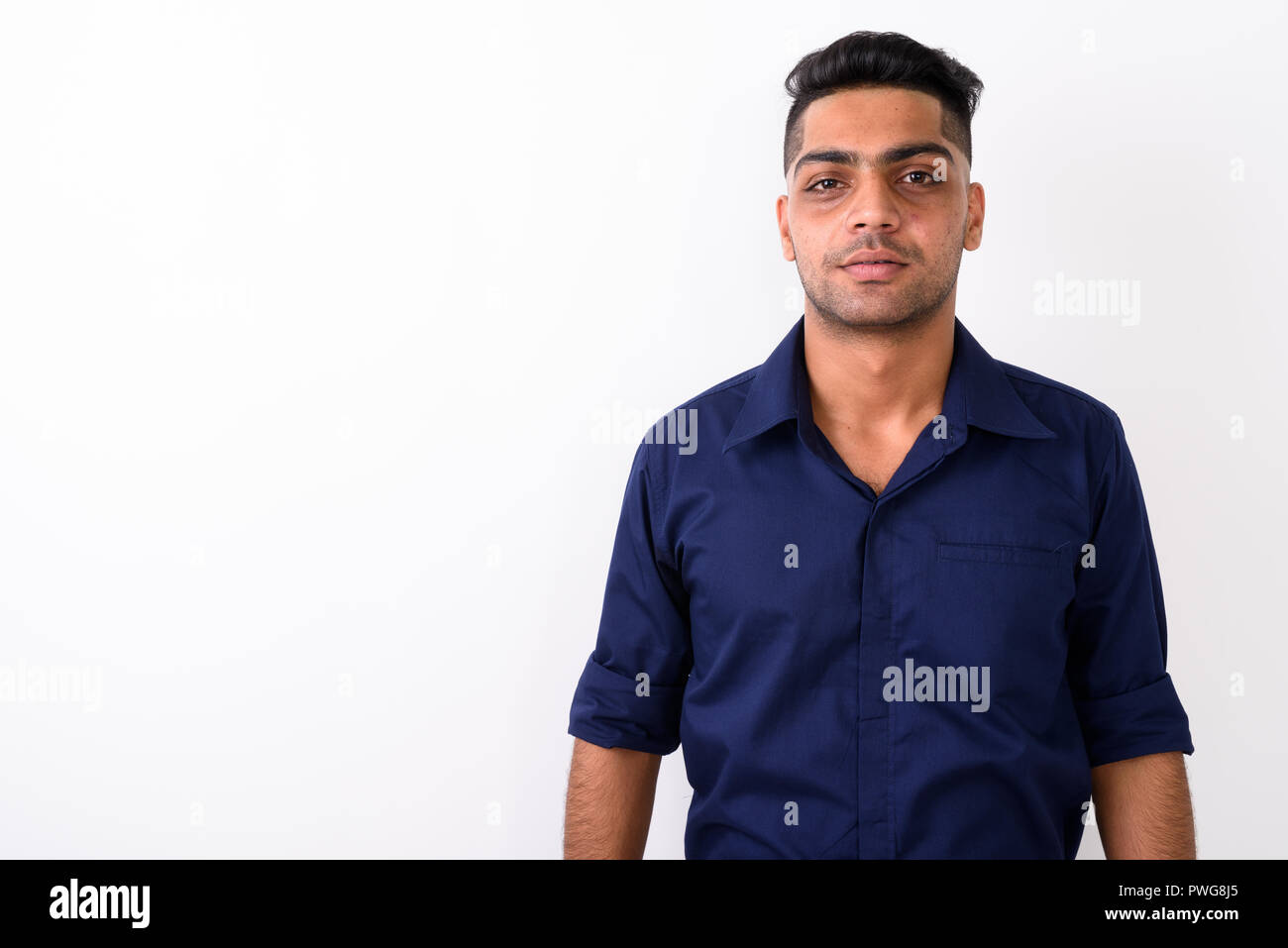 Studio shot of young Indian businessman against white background Stock Photo