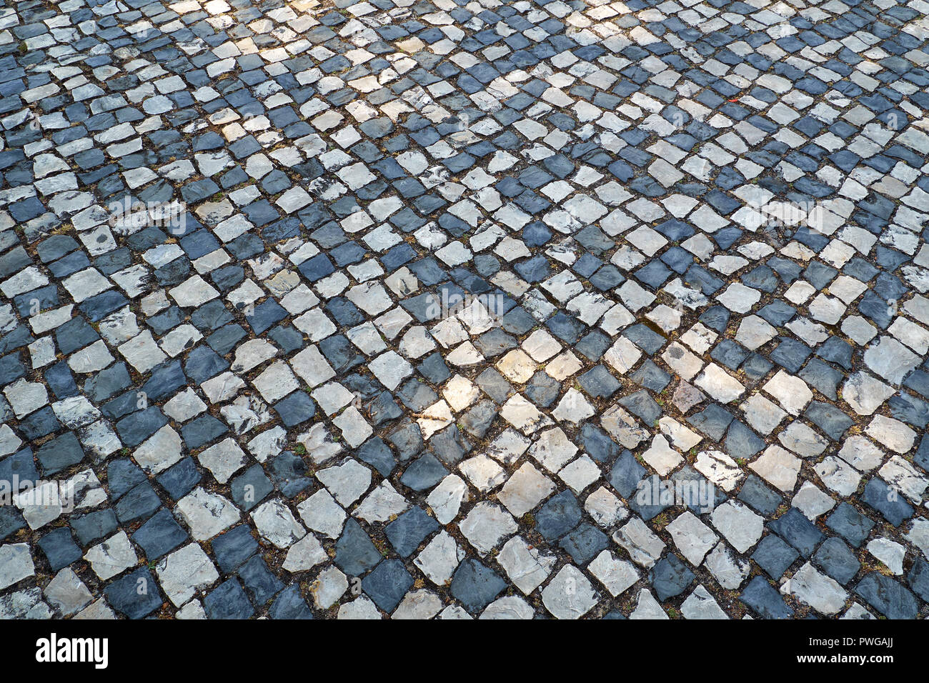 The pattern of tradition Portuguese pavement mosaic designed with black and white stones of basalt and limestone in the Park of the Nations. Lisbon. P Stock Photo