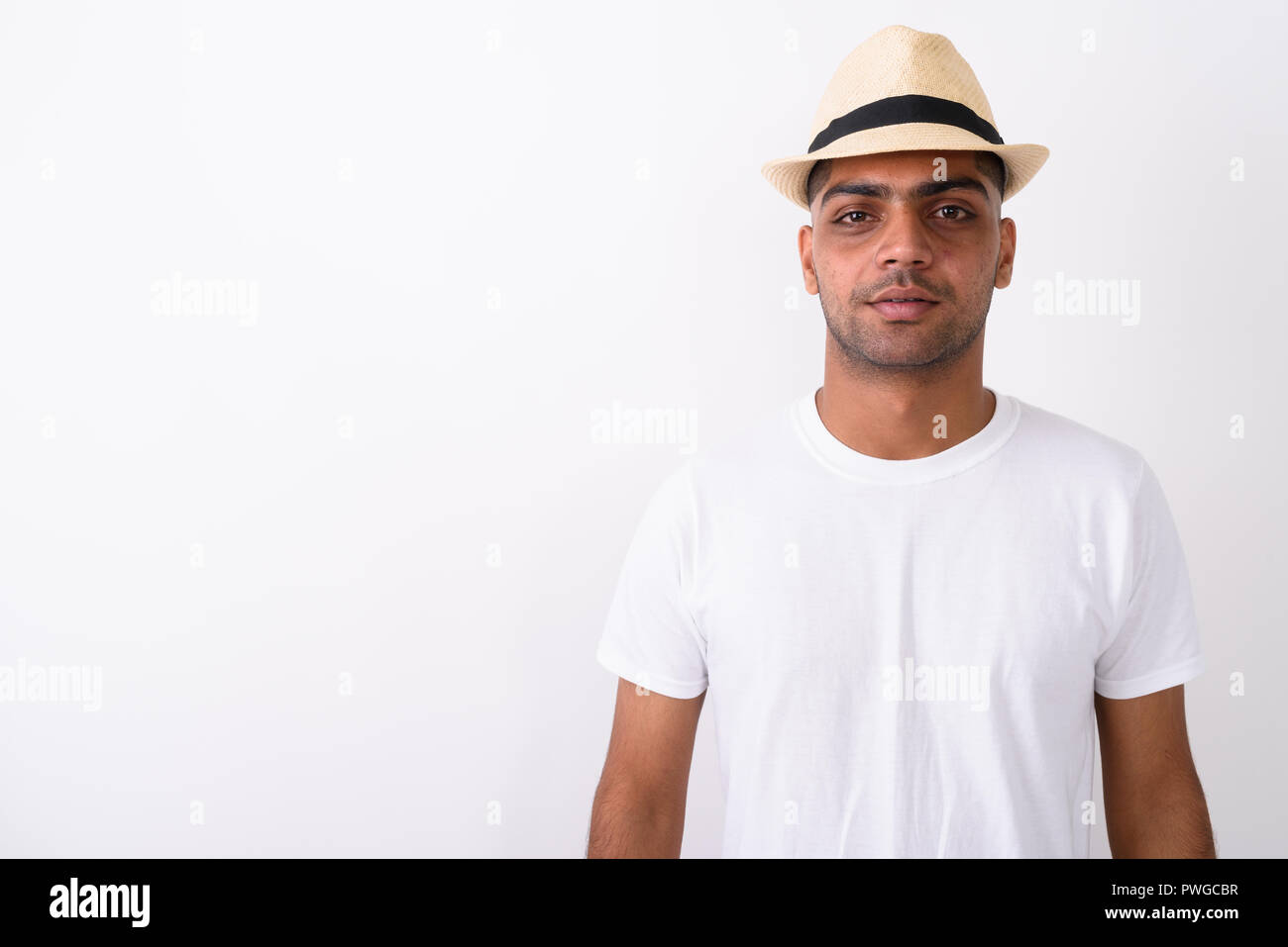 Young Indian tourist man wearing hat against white background Stock Photo