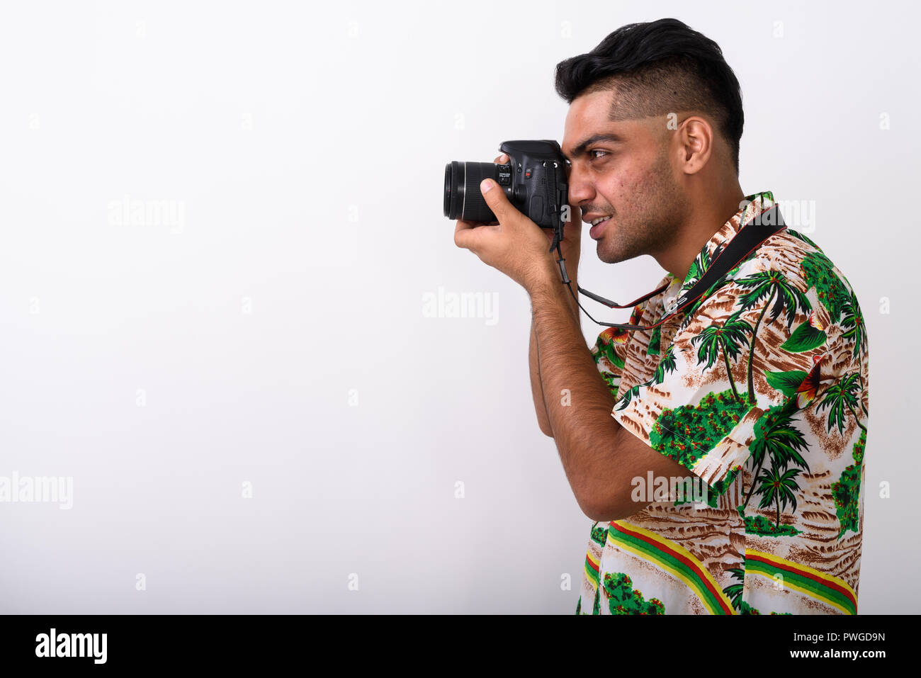 Young Indian tourist man wearing Hawaiian shirt against white ba Stock Photo