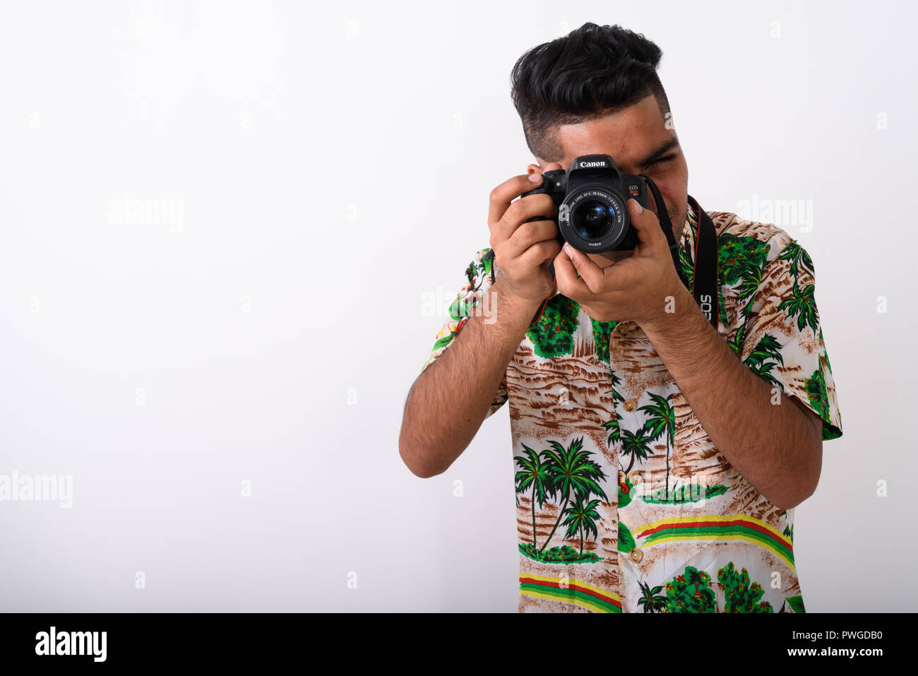 Young Indian tourist man wearing Hawaiian shirt against white ba Stock Photo
