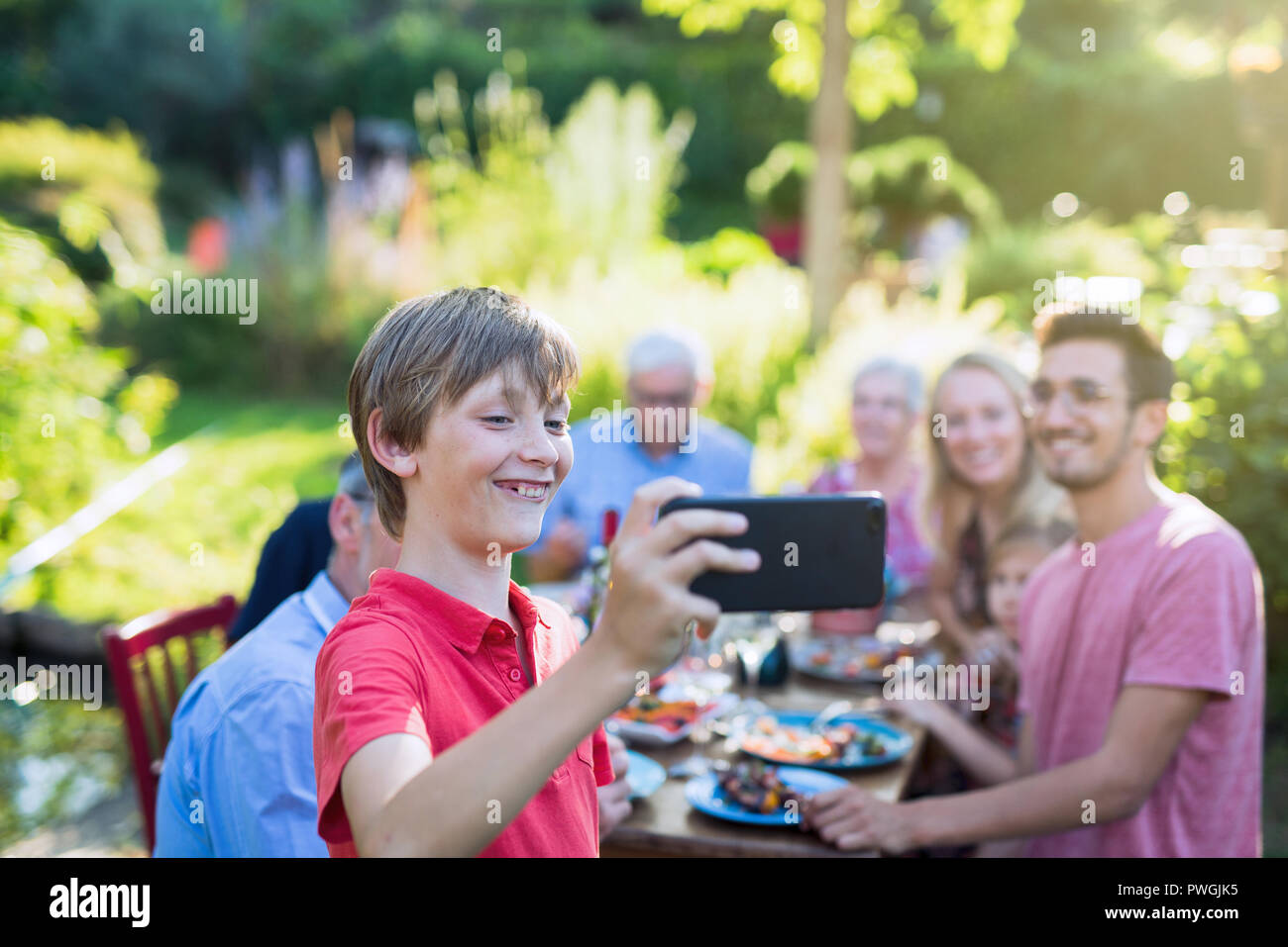 during a bbq a young boy does a selfie with the whole family Stock Photo