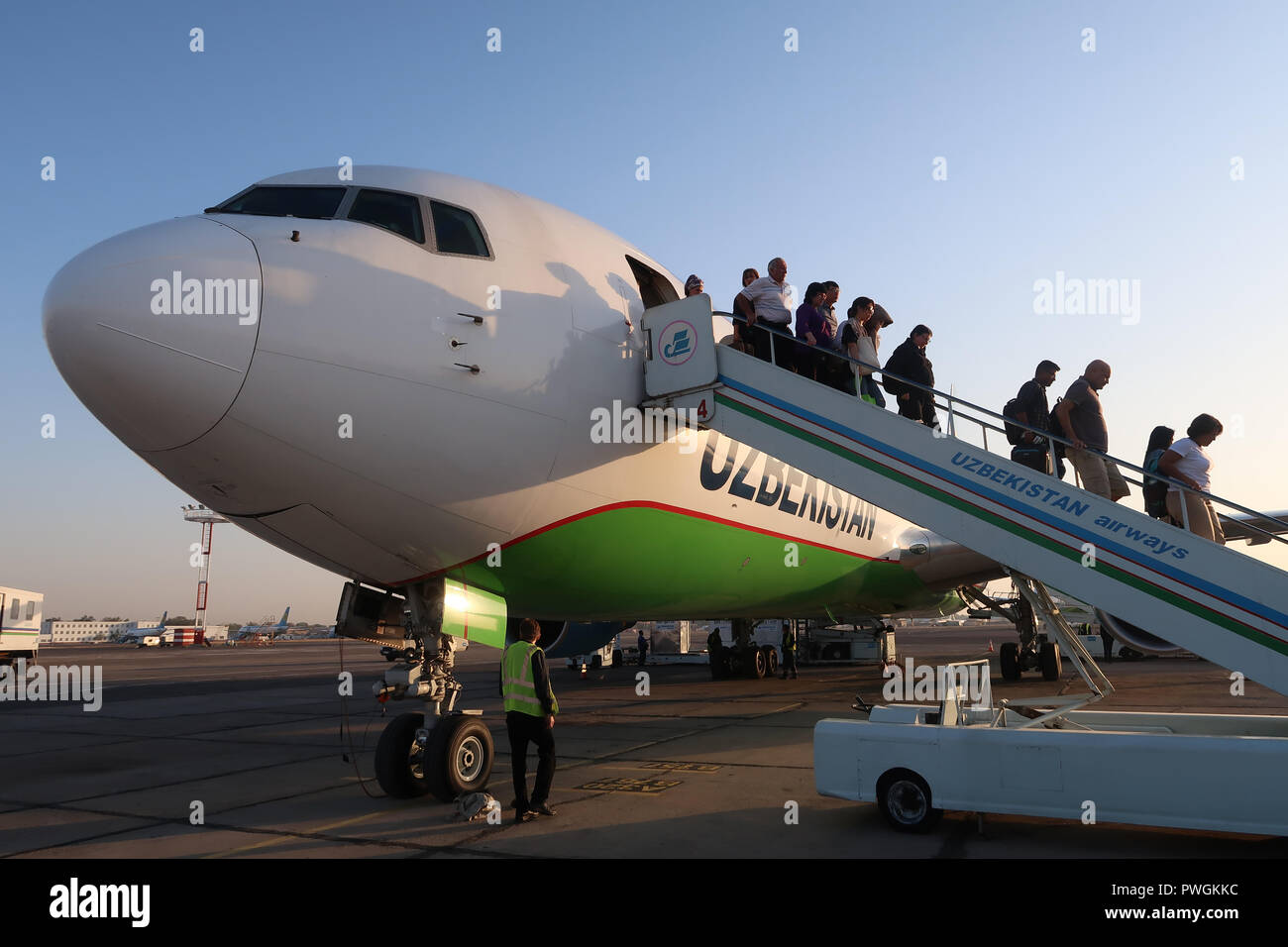Passengers disembark from an airplane of National Air Company Uzbekistan Airways at Tashkent Yuzhny International Airport Uzbekistan Stock Photo