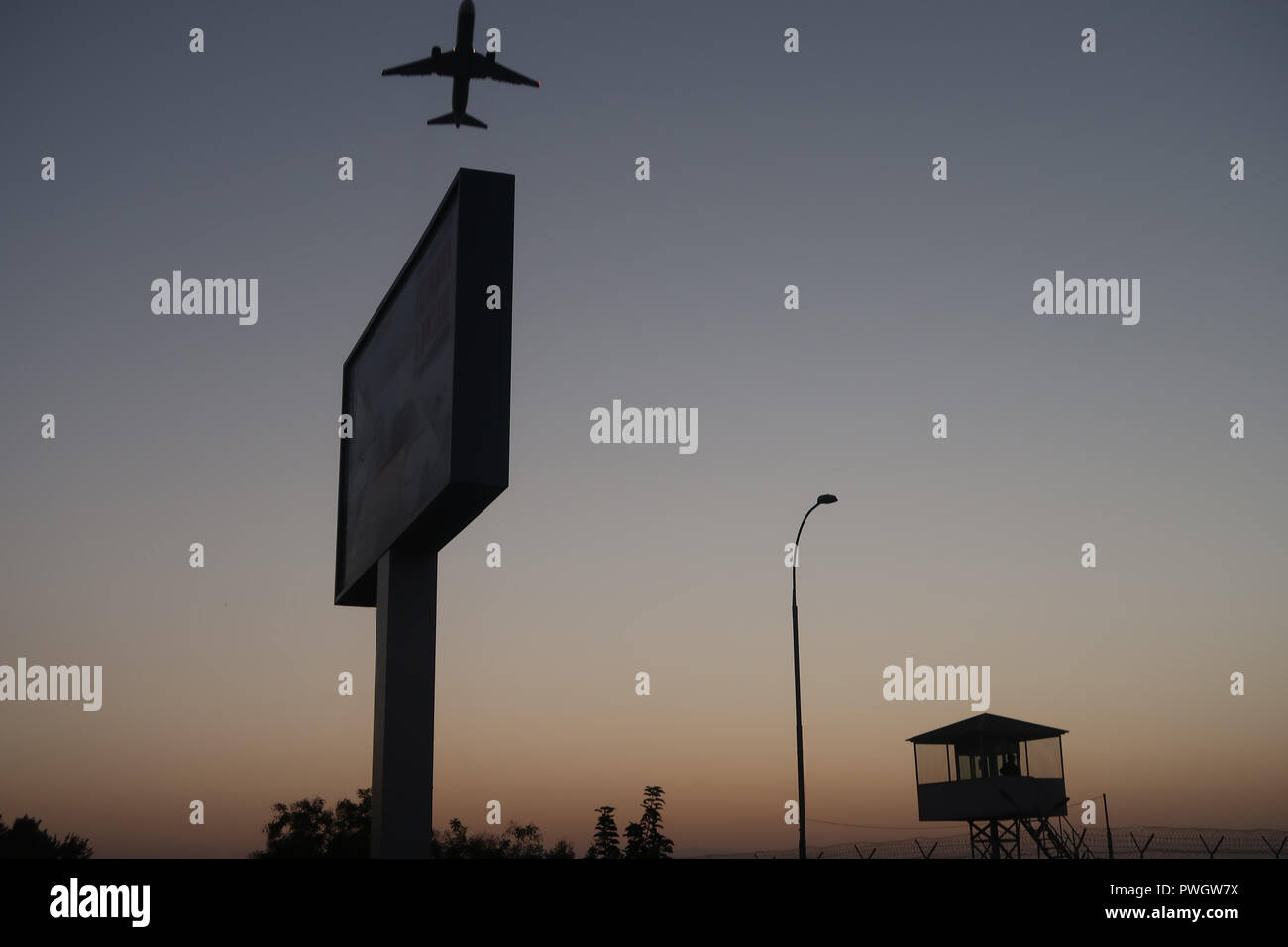 An airplane flying over a watch tower of the domestic terminal of Tashkent Airport in Tashkent capital of Uzbekistan Stock Photo
