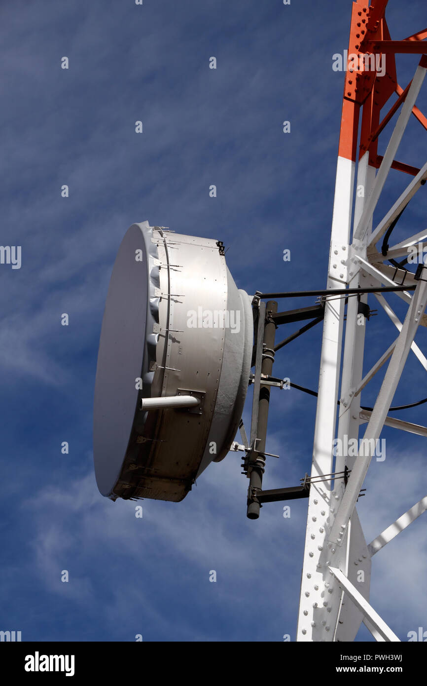 Detailed image of part of a communications tower with antenna in a