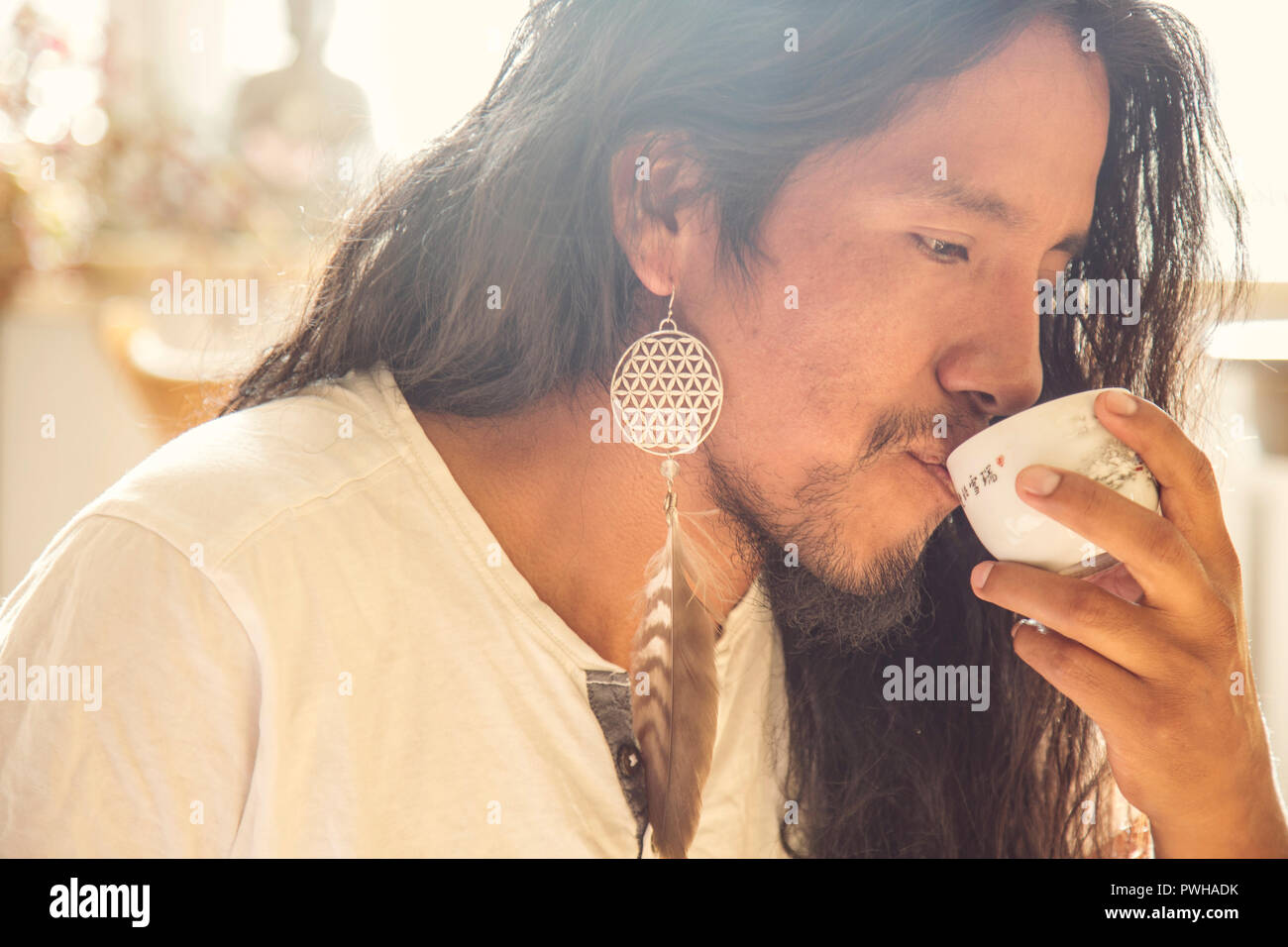 Portrait of young latino man drinking tea Stock Photo
