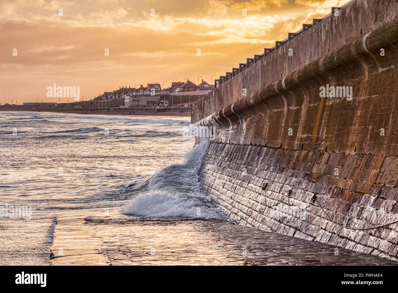 Bridlington, East Yorkshire, on a winter afternoon. A wave splashes against the sea wall. Stock Photo