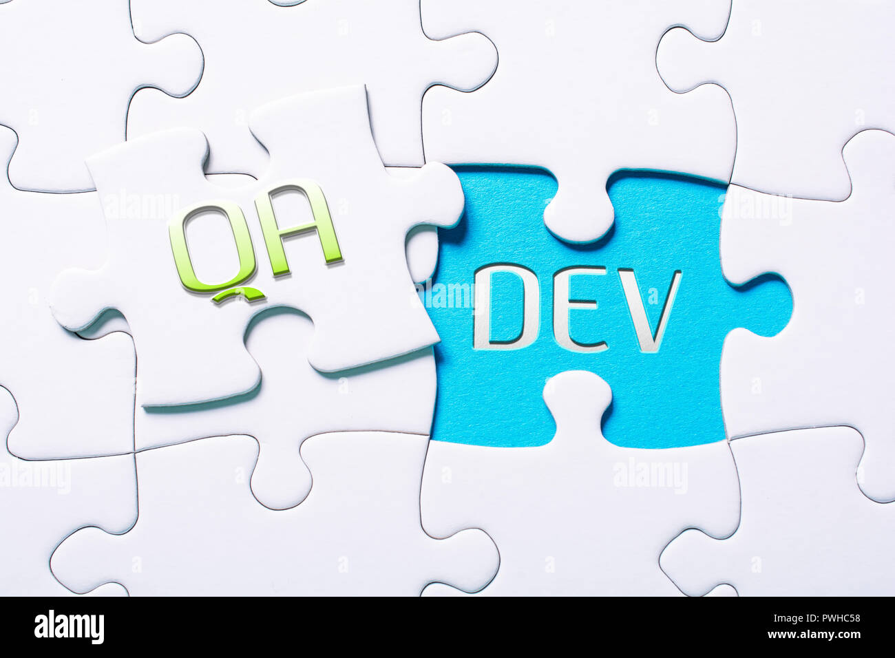 The Words QA And Dev In Missing Piece Jigsaw Puzzle Stock Photo