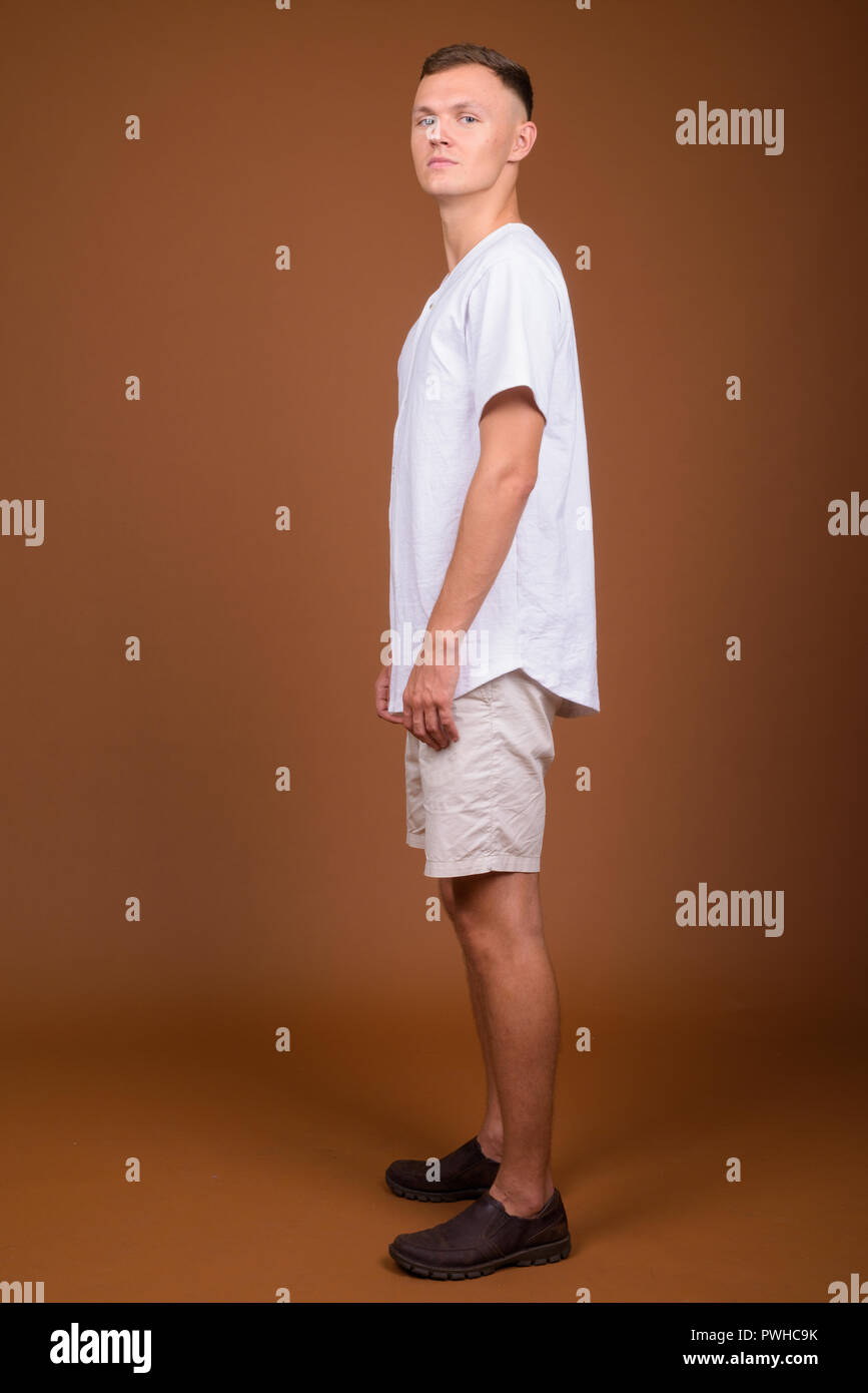 Young man wearing white shirt against brown background Stock Photo