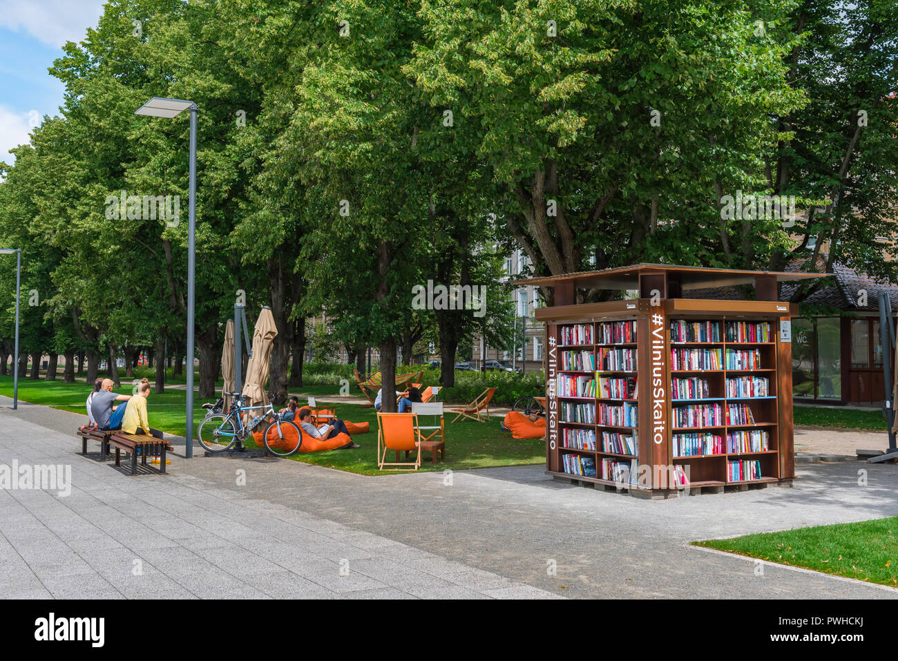 Vilnius city park, view of Lithuanian people relaxing near a courtesy bookstand in a corner of Lukiskiu aikste city park in the Vilnius New Town area. Stock Photo