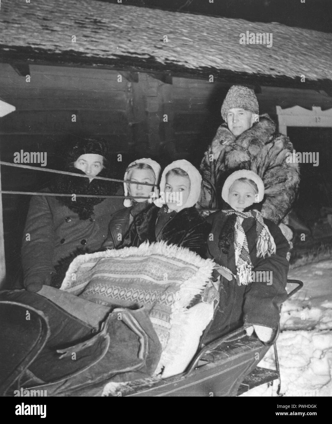 Christmas 1940s. A family is ready to go to the early service in church on christmas morning. A father and his three girls are well dressed for the freezing cold weather. Sweden 1944 Stock Photo