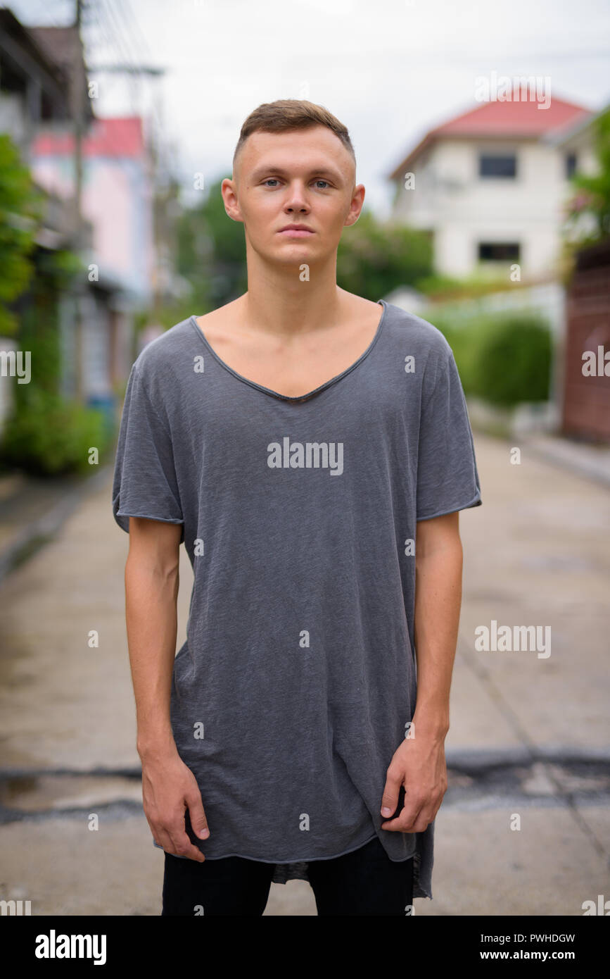 Young man wearing gray shirt in the streets outdoors Stock Photo