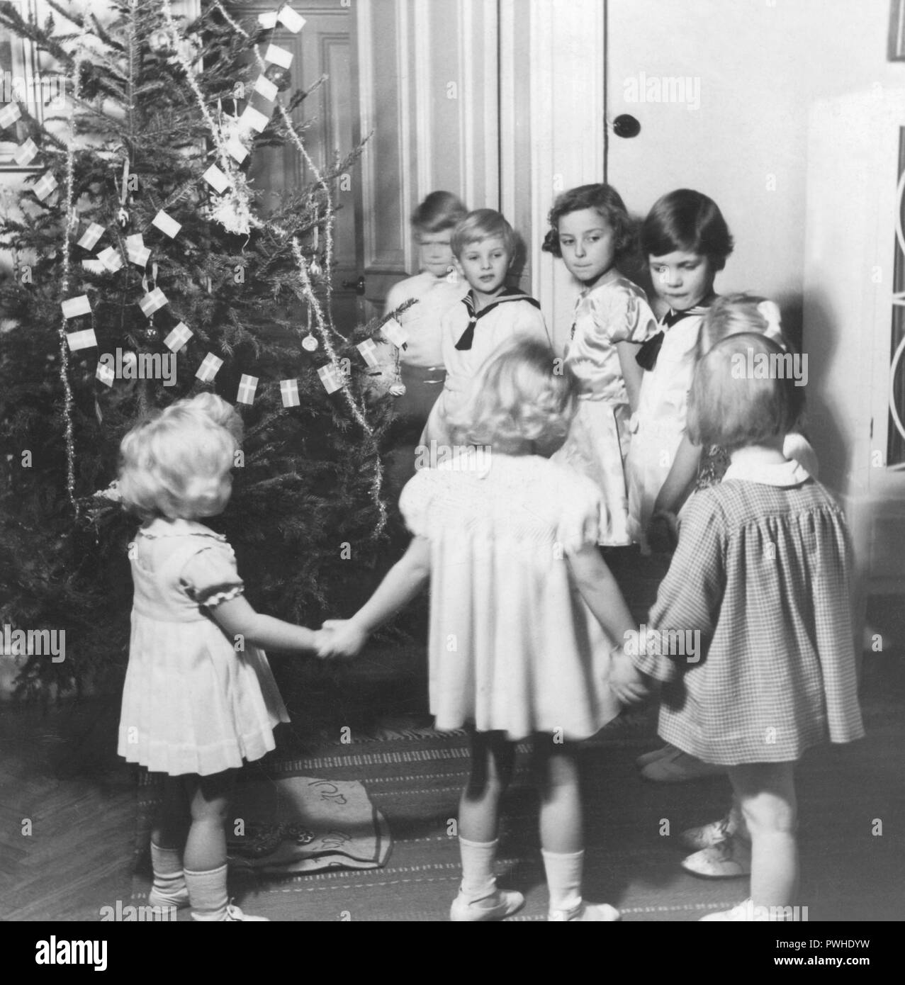 Christmas in the 1940s. Children are dancing around the christmas tree. Sweden 1947 Stock Photo