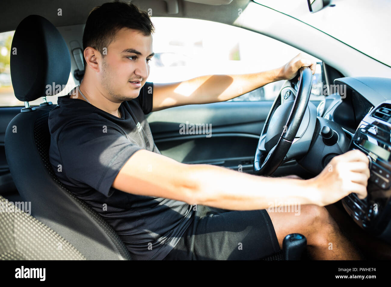 Man is going to drive, looking for some nice music Stock Photo