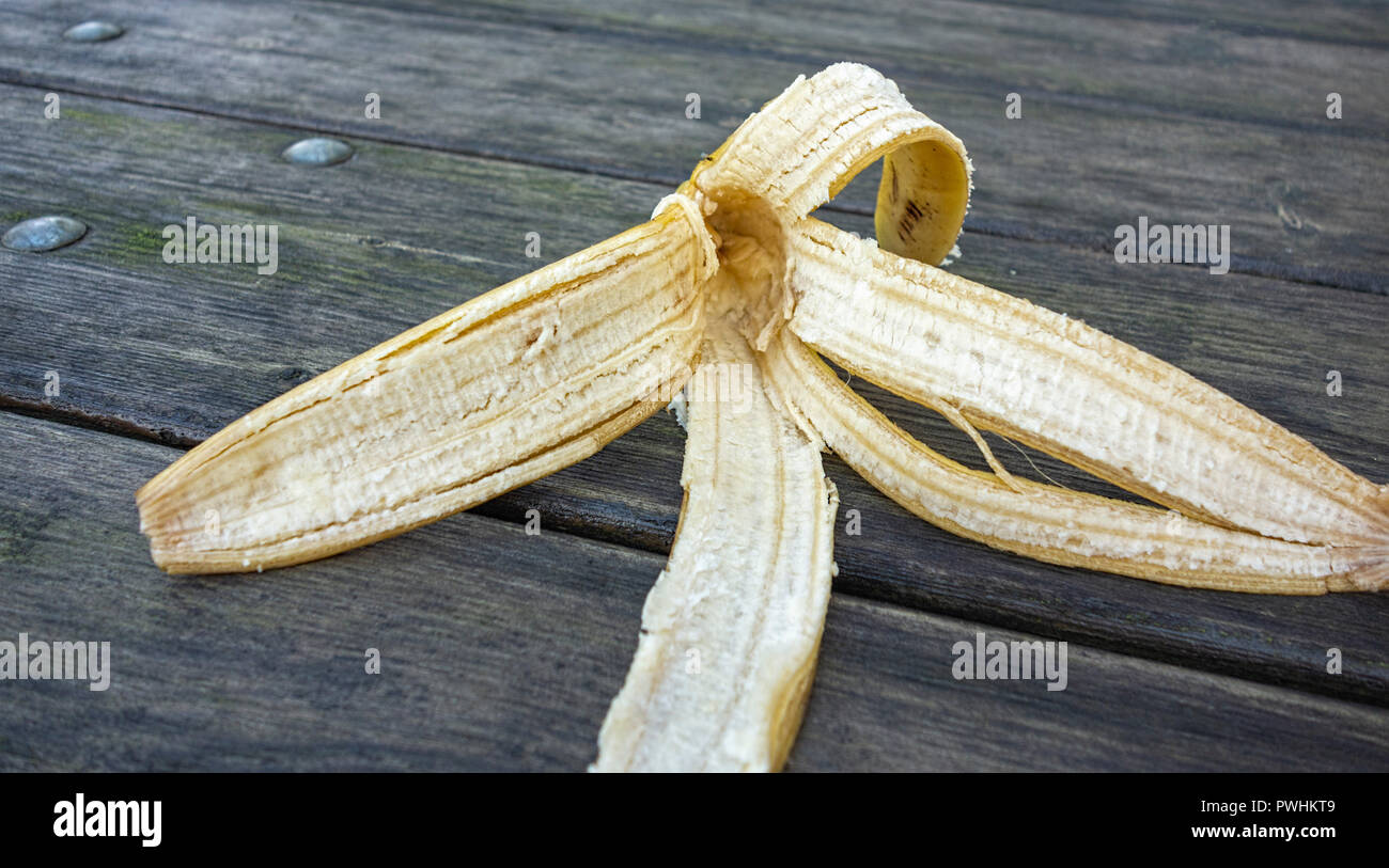 Discarded banana skin on wooden table Stock Photo