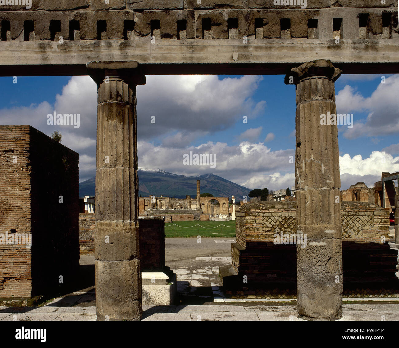 Italy. Pompeii. Roman city destroyed in 79 AD because of the eruption of the Vesuvius volcano. In the foregorund, Portico of the Samnite period. At the background, remains of the Doric columns of the Temple of Jupiter (Fortuna Augusta) at the Forum. La Campania. Stock Photo