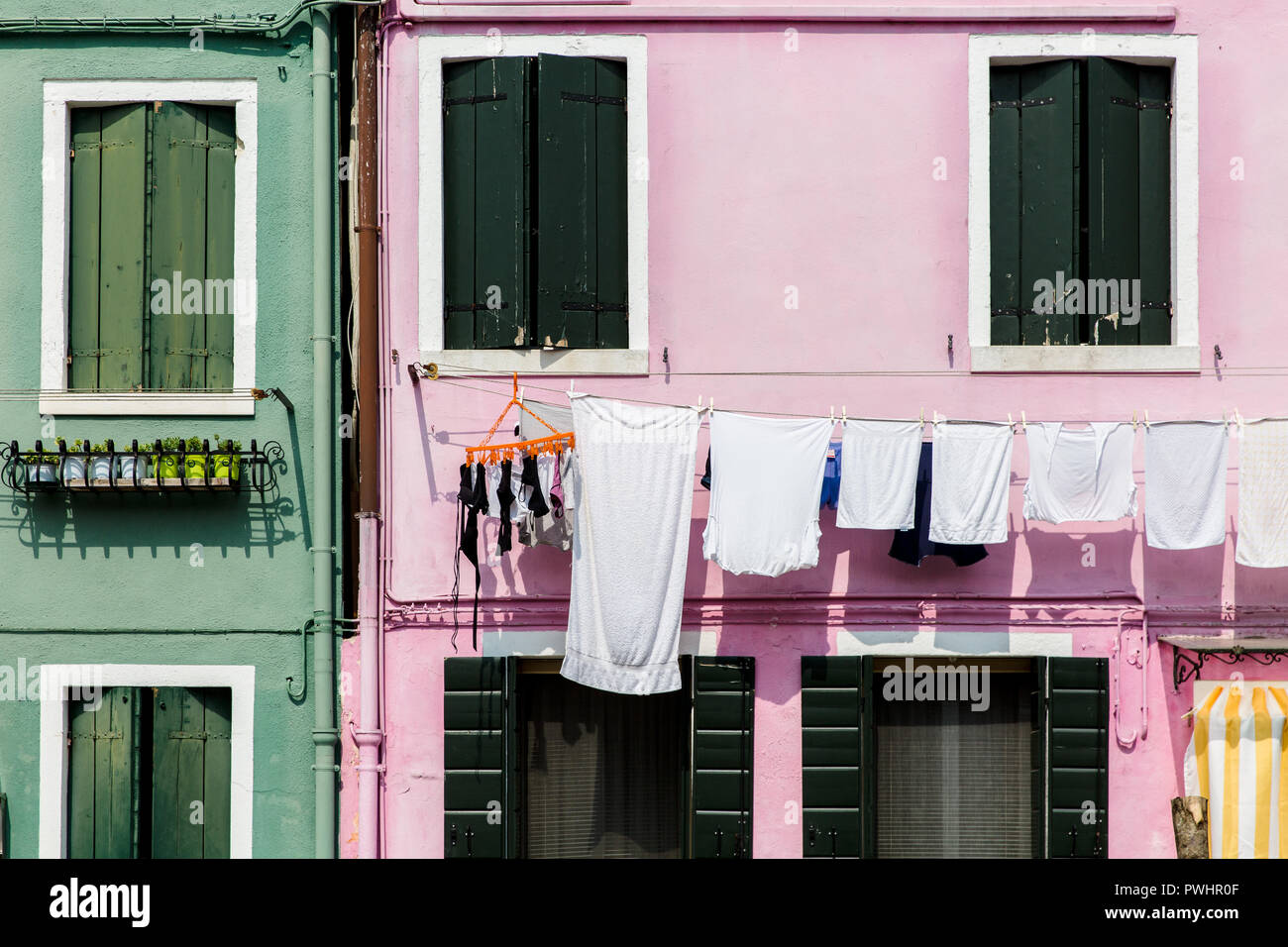 Washing line on traditional pink house in the rainbow island of Burano, Venice, Italy Stock Photo