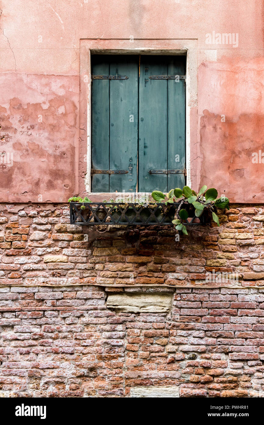 A traditional window on a red bricked house in Venice, Italy Stock Photo