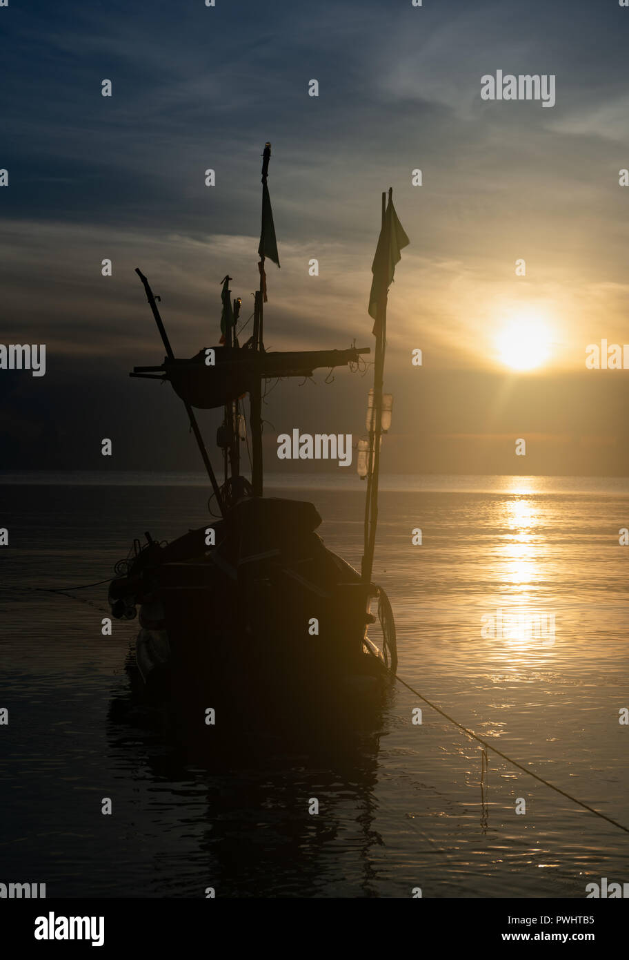 Small fishing boat on the sea during sunset Stock Photo