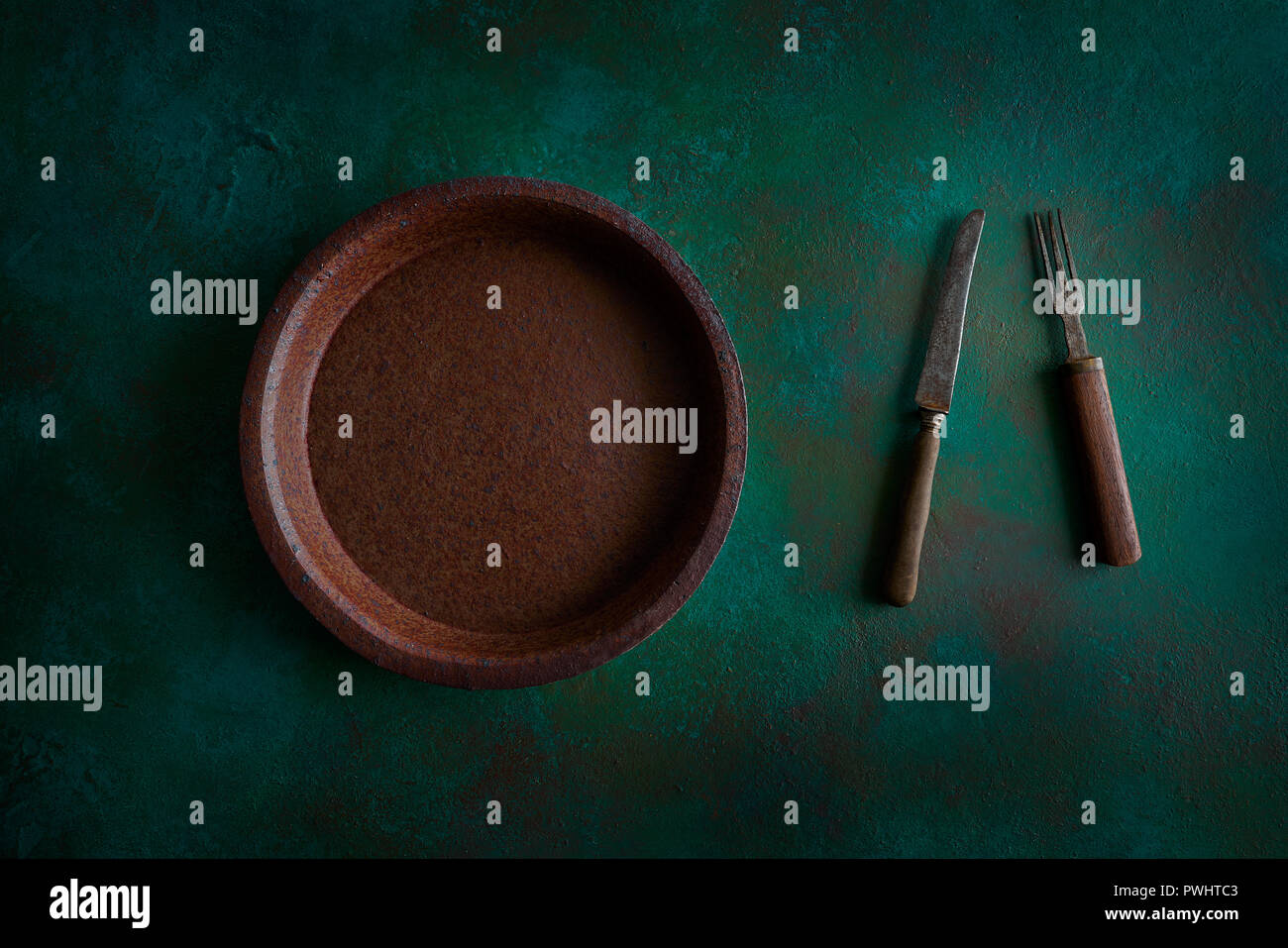 Ceramic tableware pottery plate on grunge green background Stock Photo