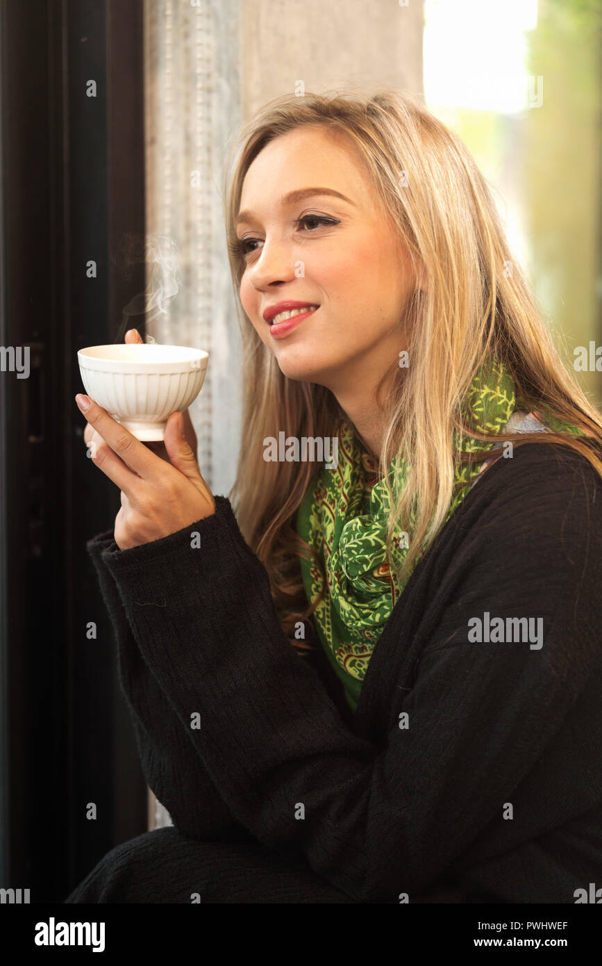 Young woman drinking tea at the coffee shop Stock Photo