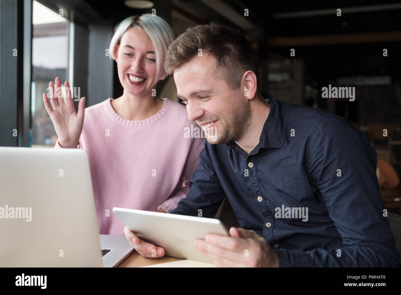 Two coworkers working together on laptop. Pretty experienced woman ...