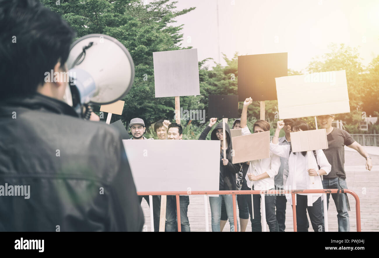 Group of protesters holding protest signs walking at the street Stock Photo