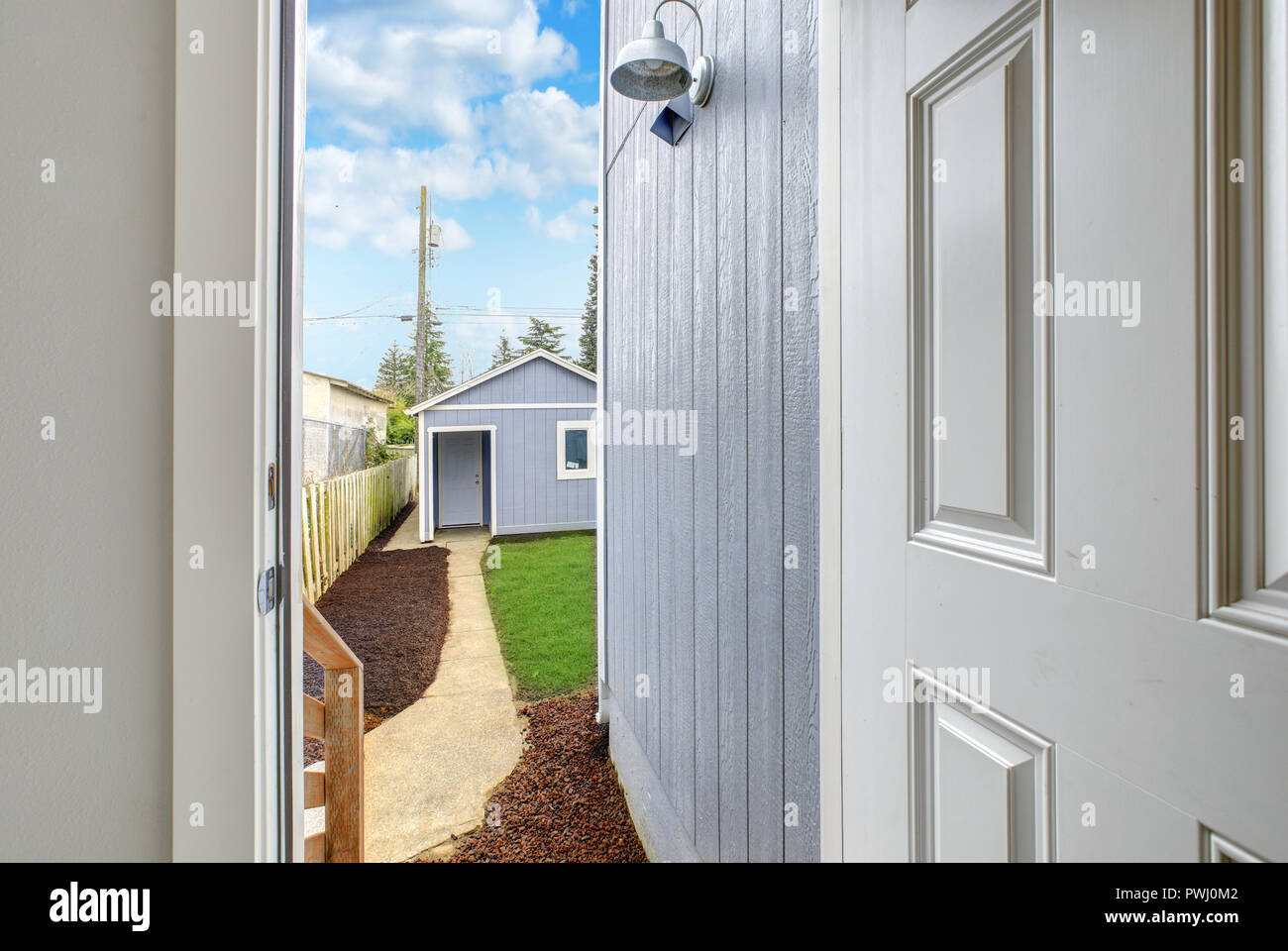 Open door to back yard with shed view. Stock Photo