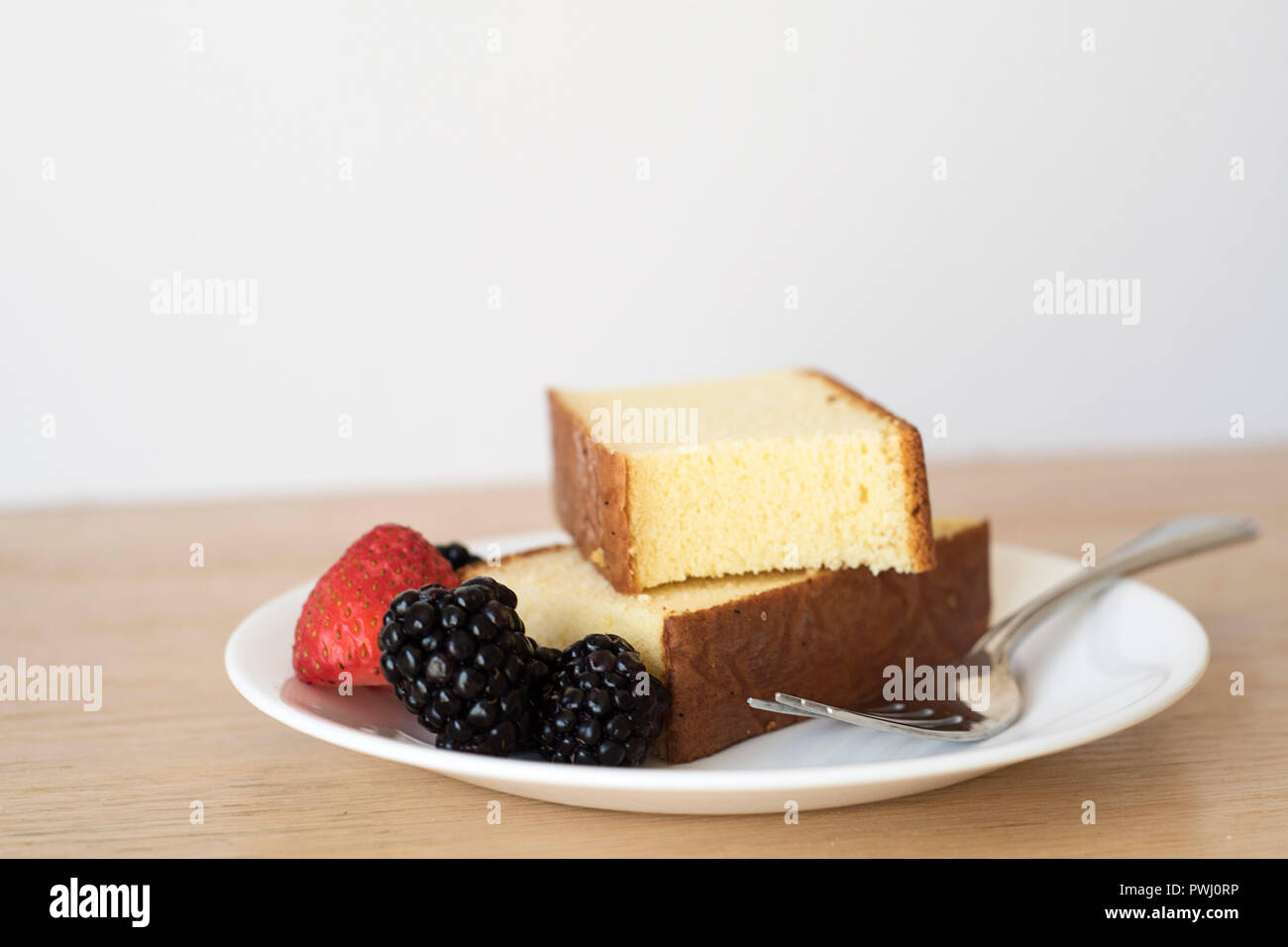 Pound Cake Slices Stacked on a Plate with Berries for a Snack, Dessert, or Breakfast. Horizontal. Stock Photo