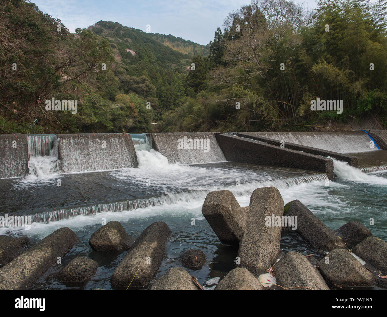 River control, weir shaping river flow with tetrapods below, Iyoki River, Kochi, Shikoku, Japan Stock Photo