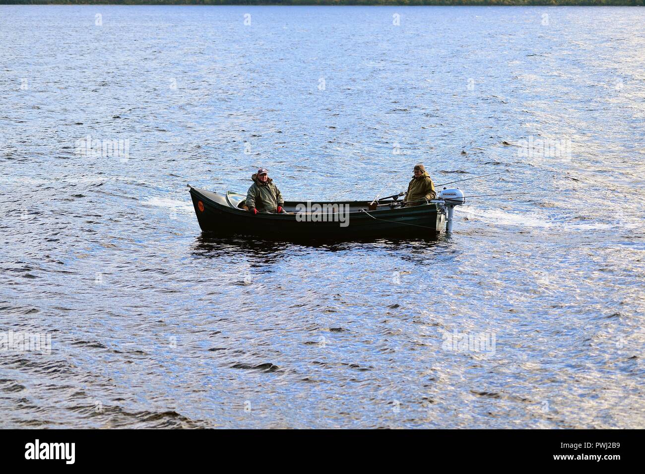 Drumnadrochit, Highlands, Scotland, United Kingdom. A pair of bundled-up fisherman testing the waters of Loch Ness. Tolling for Nessie, perhaps? Stock Photo