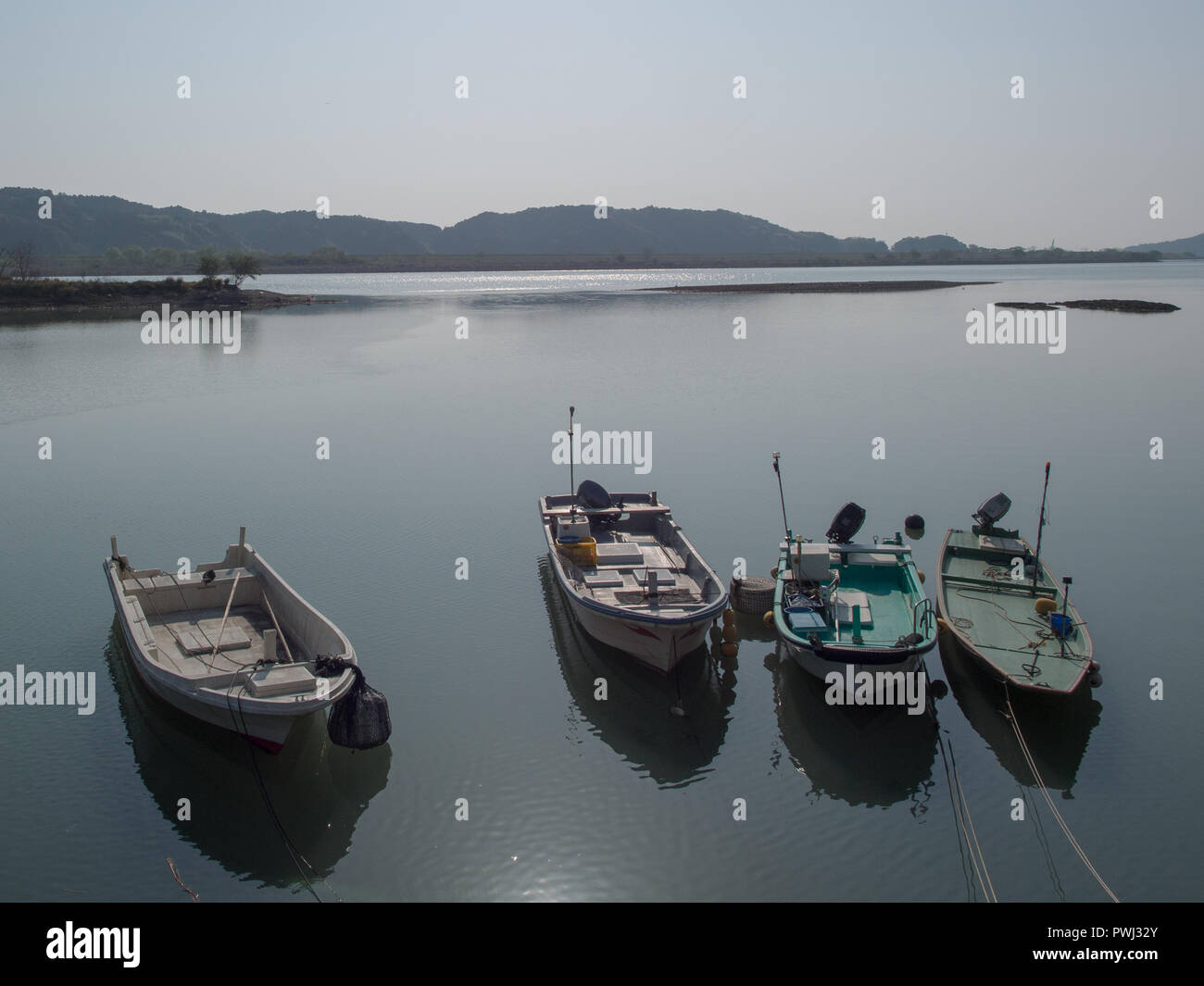 Four fishing boats,  moored dinghys, calm still day,  estuary Shimanto River, Kochi, Shikoku, Japan Stock Photo