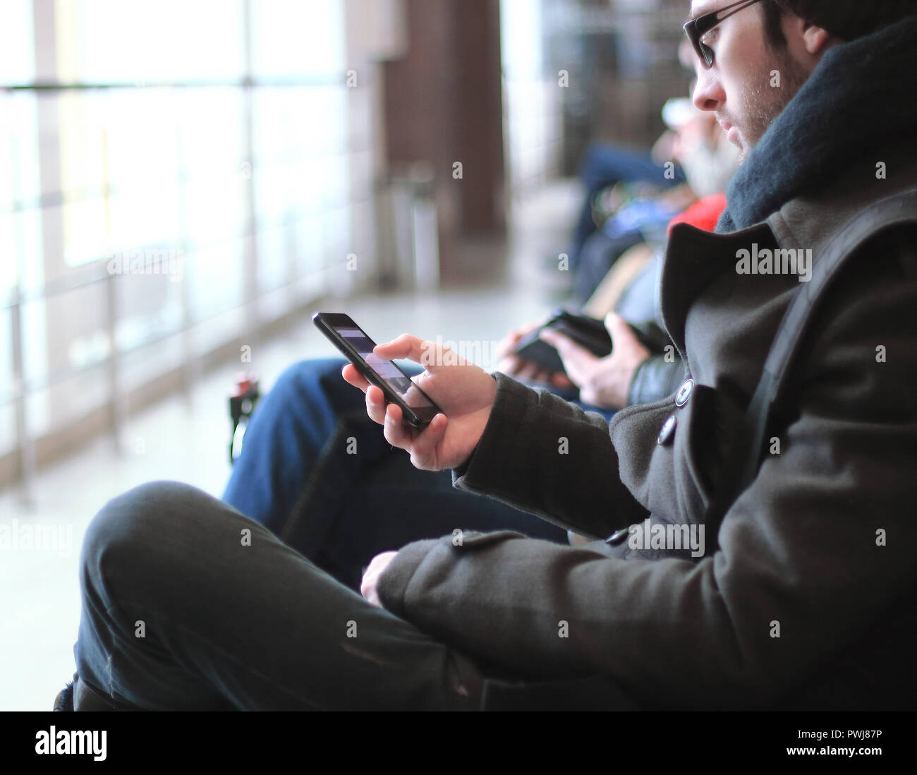 close up.modern man with smartphone sitting in airport building Stock Photo