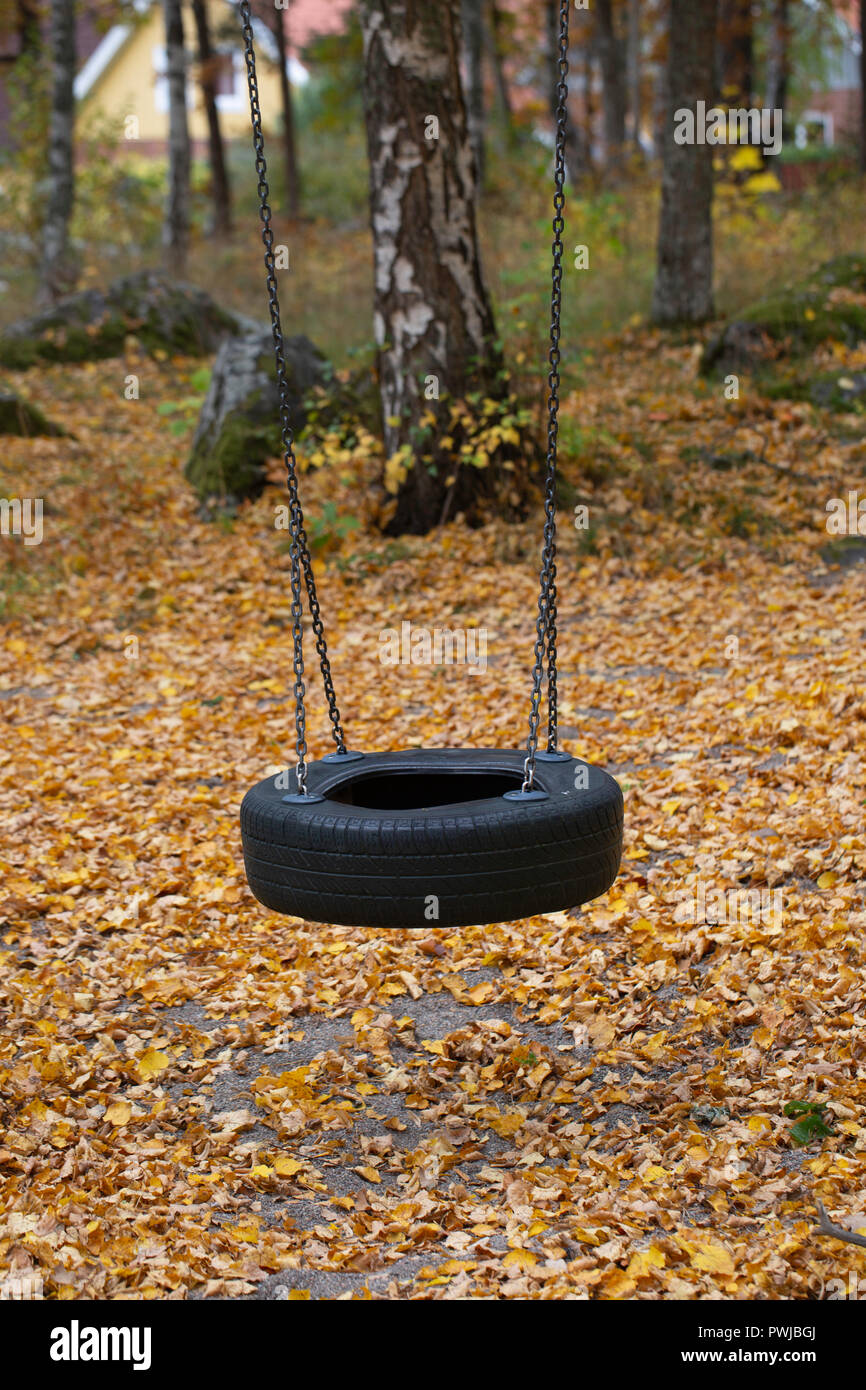 A child's tyre swing in a playground in the autumn Stock Photo