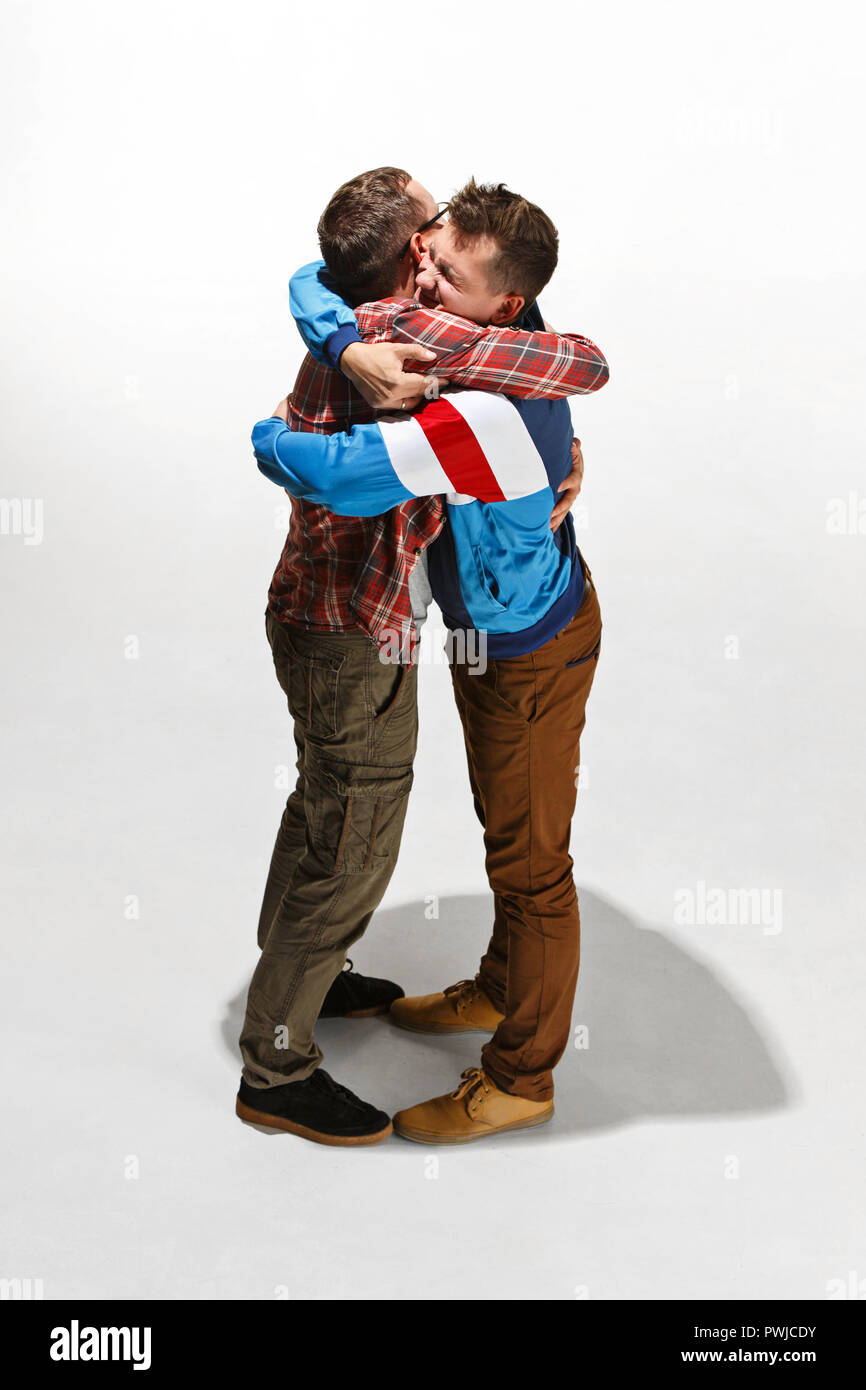 Two friends in casual colorful wear standing and laughing together. Best friends enjoying life. Two men having fun. Hugging day concepts Stock Photo