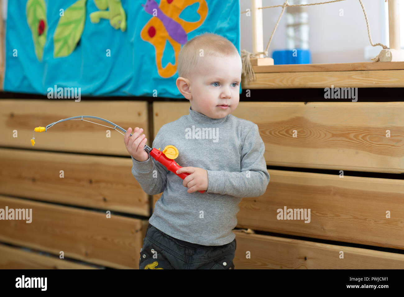 Kid playing toy rod in kindergarten or daycare centre Stock Photo