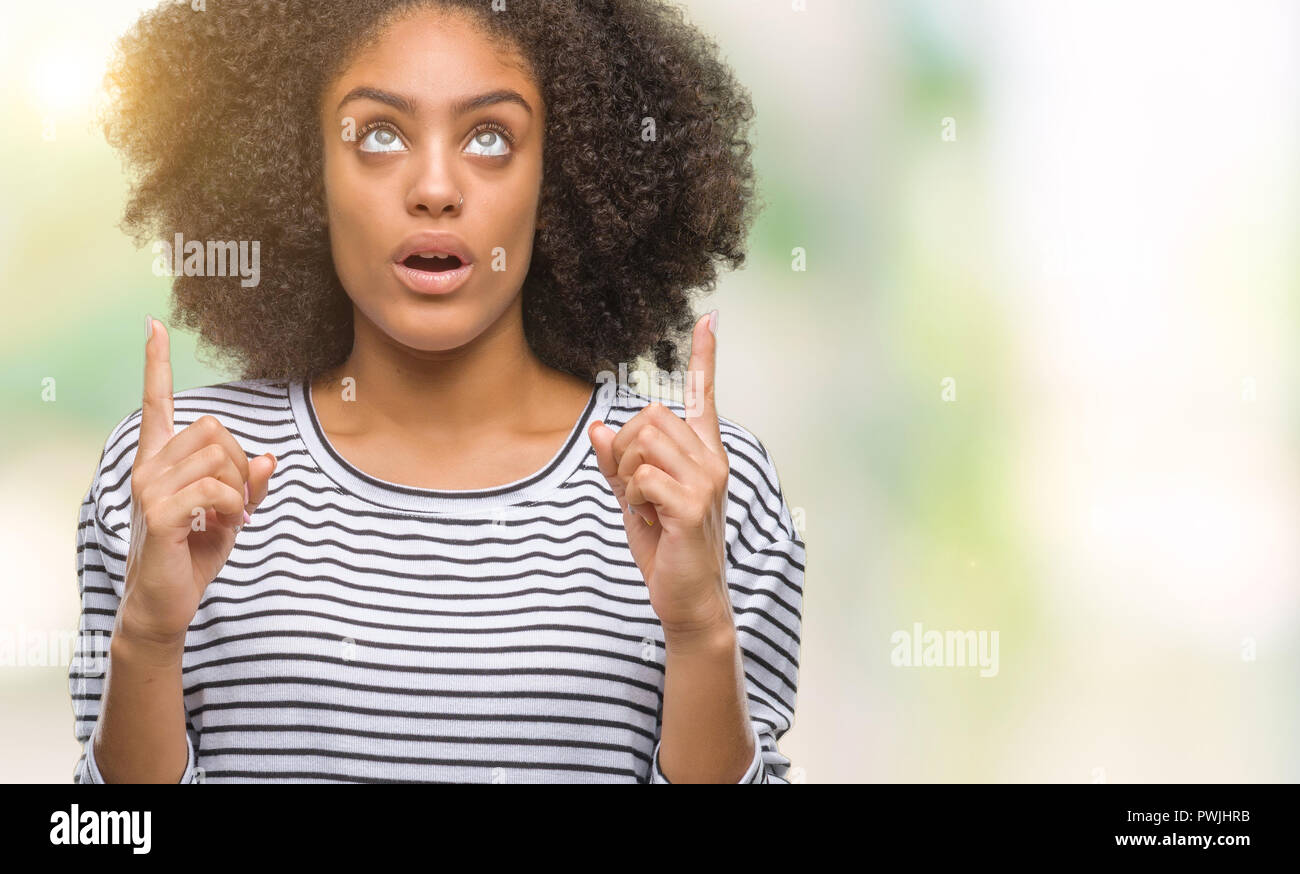 Young afro american woman over isolated background amazed and surprised ...