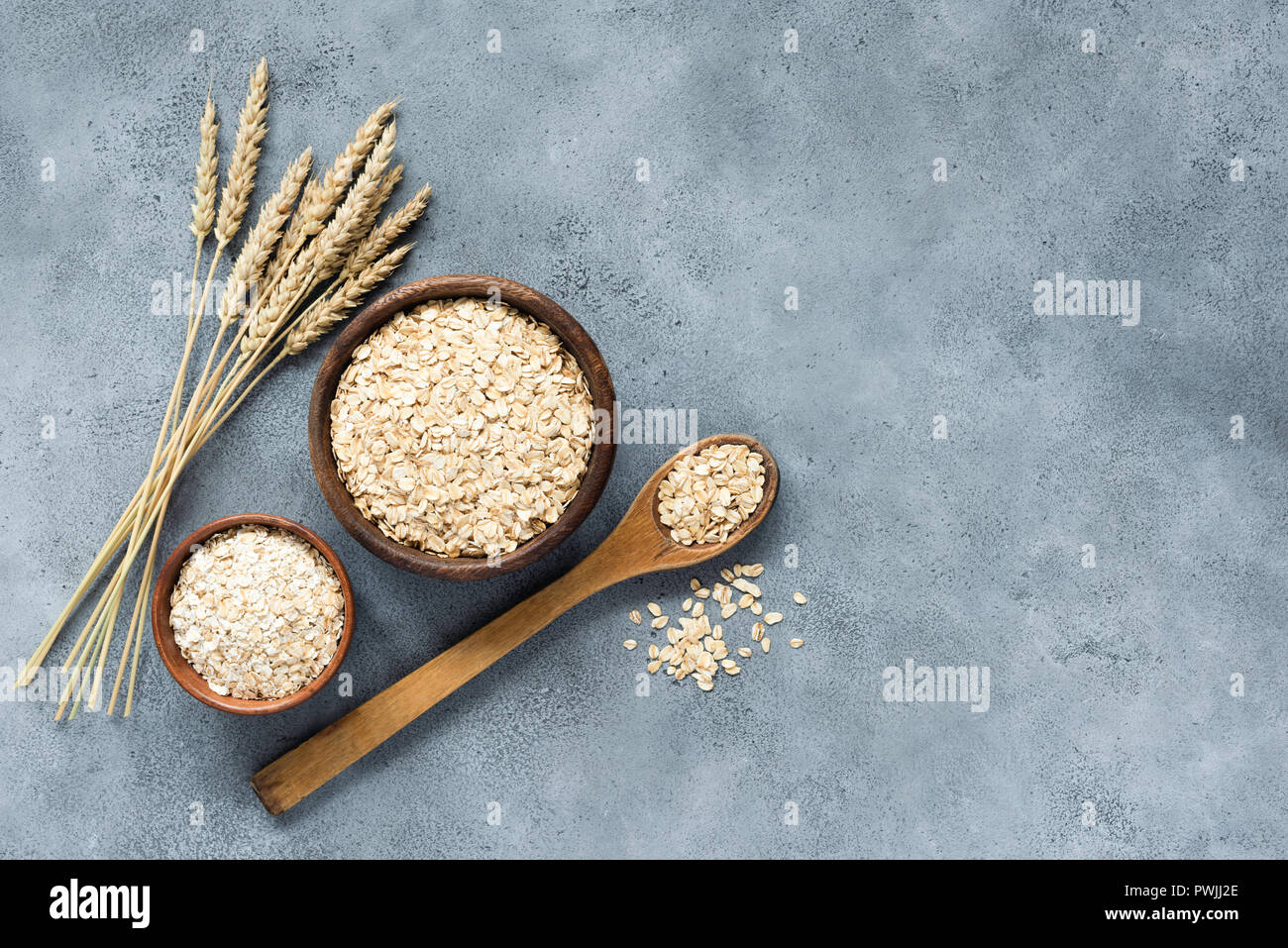 Oats, rolled oats and oat flakes in wooden bowl, top view. Concept of healthy eating, healthy lifestyle, dieting and vegetarian food Stock Photo
