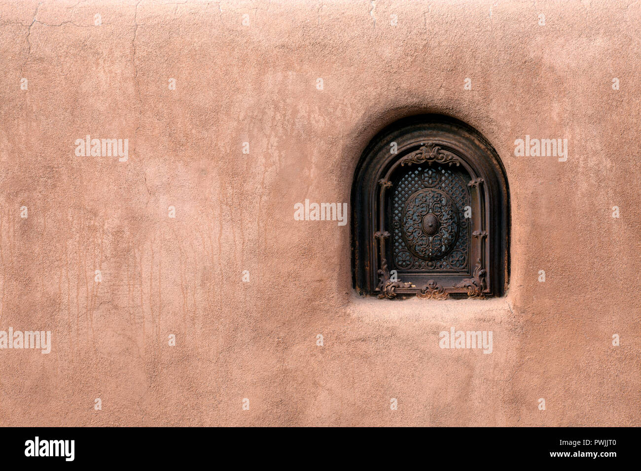 Old adobe wall security window in Santa Fe, New Mexico. Stock Photo