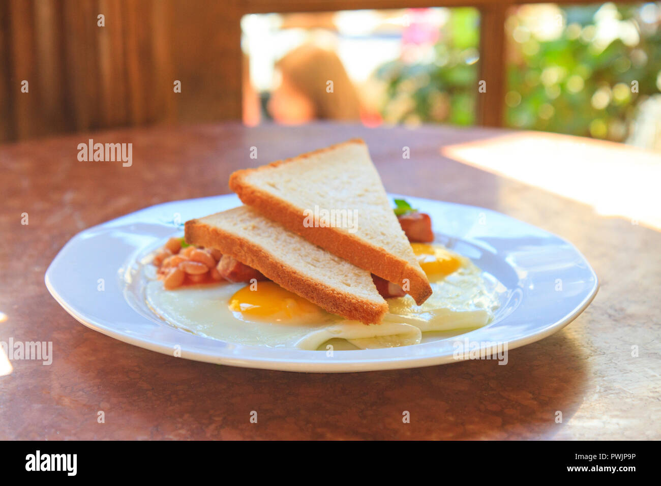 egg with beans and toast on a white plate Stock Photo