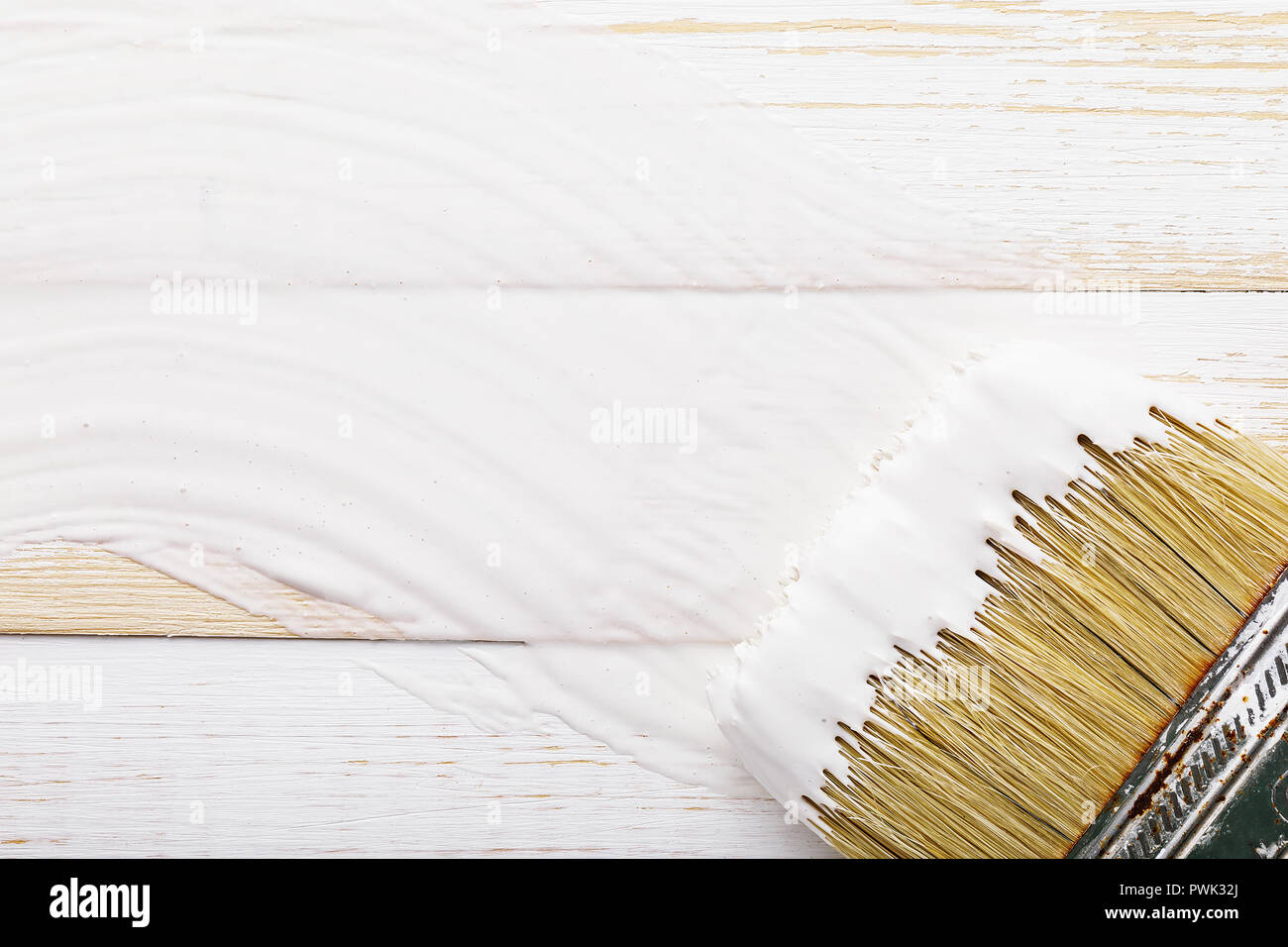 Paint brush in white paint on wooden board with copy space Stock Photo ...