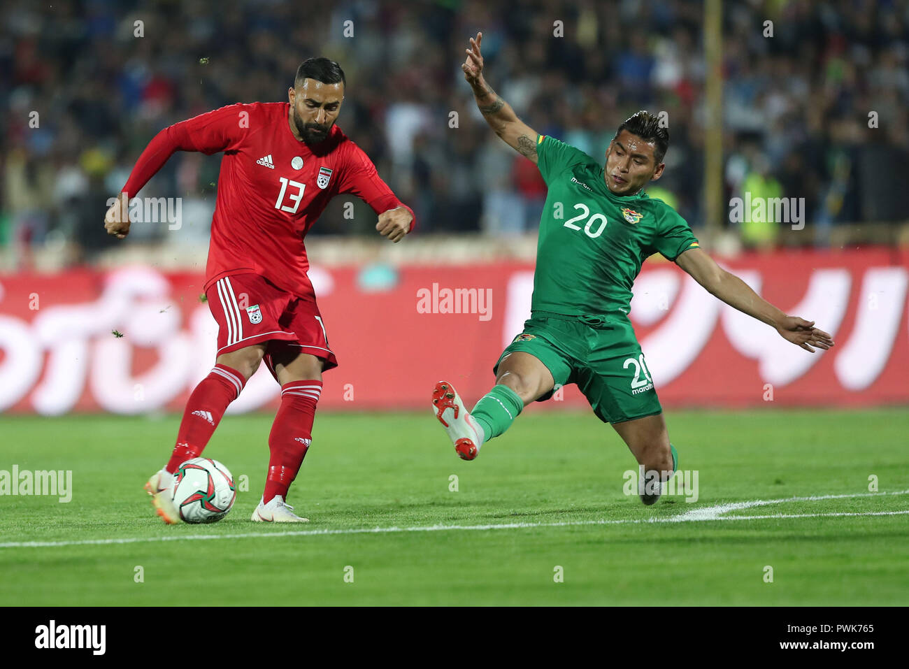 Tehran, Iran. 16th Oct, 2018. Iran's Saman Ghoddos and Bolivia's Rudy Cardozo battle for the ball during an International Friendly soccer match between Iran and Bolivia at the Azadi Stadium. The Iranian authorities have allowed women to attend the match after a request from the Football Federation of the Islamic Republic of Iran. Credit: Saeid Zareian/dpa/Alamy Live News Stock Photo