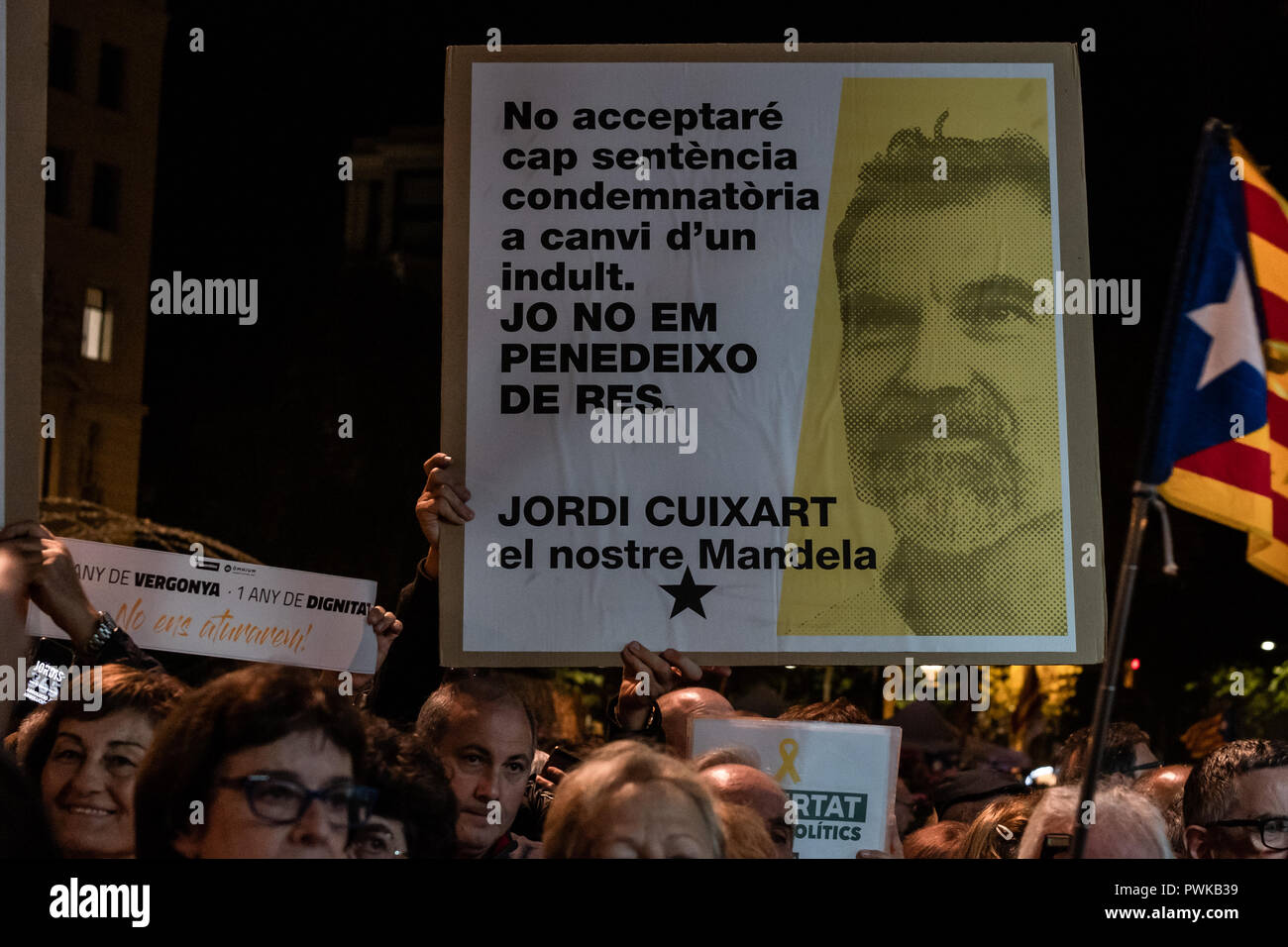 Protesters are seen holding a poster with the portrait of Jordi Cuixart during the protest. Thousands of people protest demanding for the freedom of Jordi Cuixart and Jordi Sànchez, 'los Jordis' after 1 year in prison, under the motto a year of shame, a year of dignity, they will not stop us. Stock Photo
