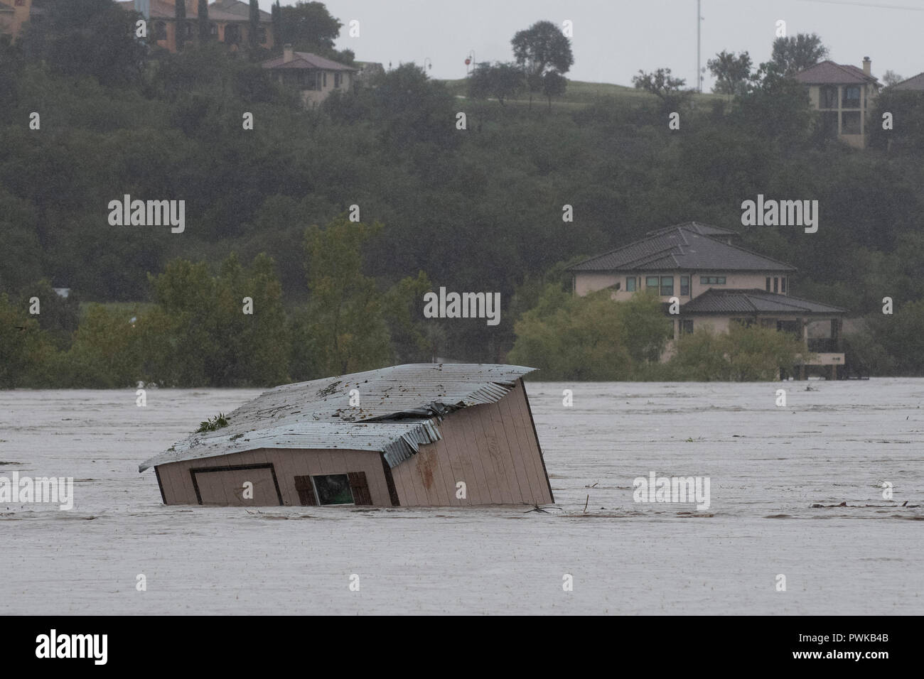 A boat dock ripped from its mooring by floodwaters floats down the swollen Colorado River in Marble Falls, Texas. Stock Photo