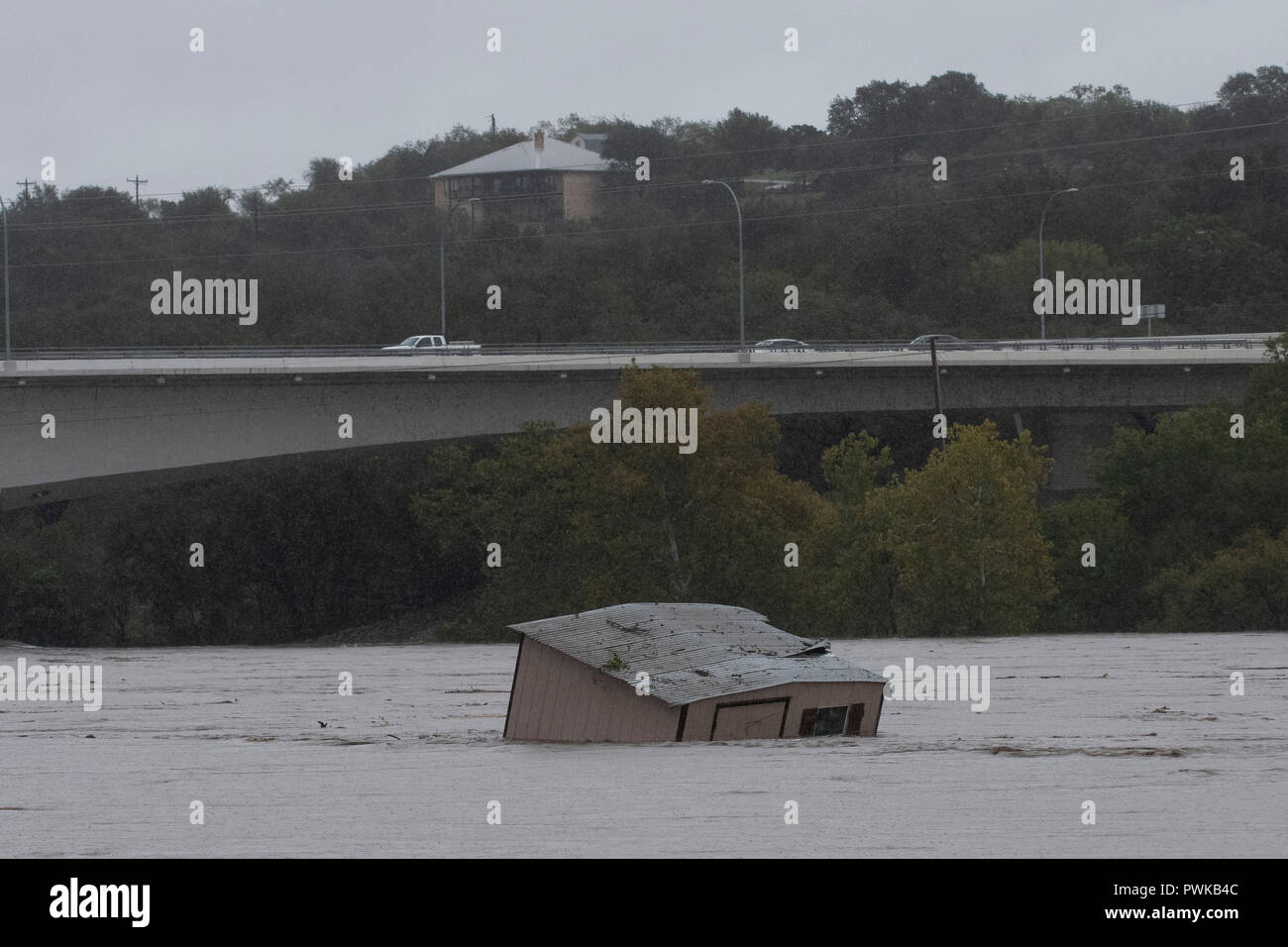 A boat dock ripped from its mooring by floodwaters floats down the swollen Colorado River in Marble Falls, Texas. Stock Photo