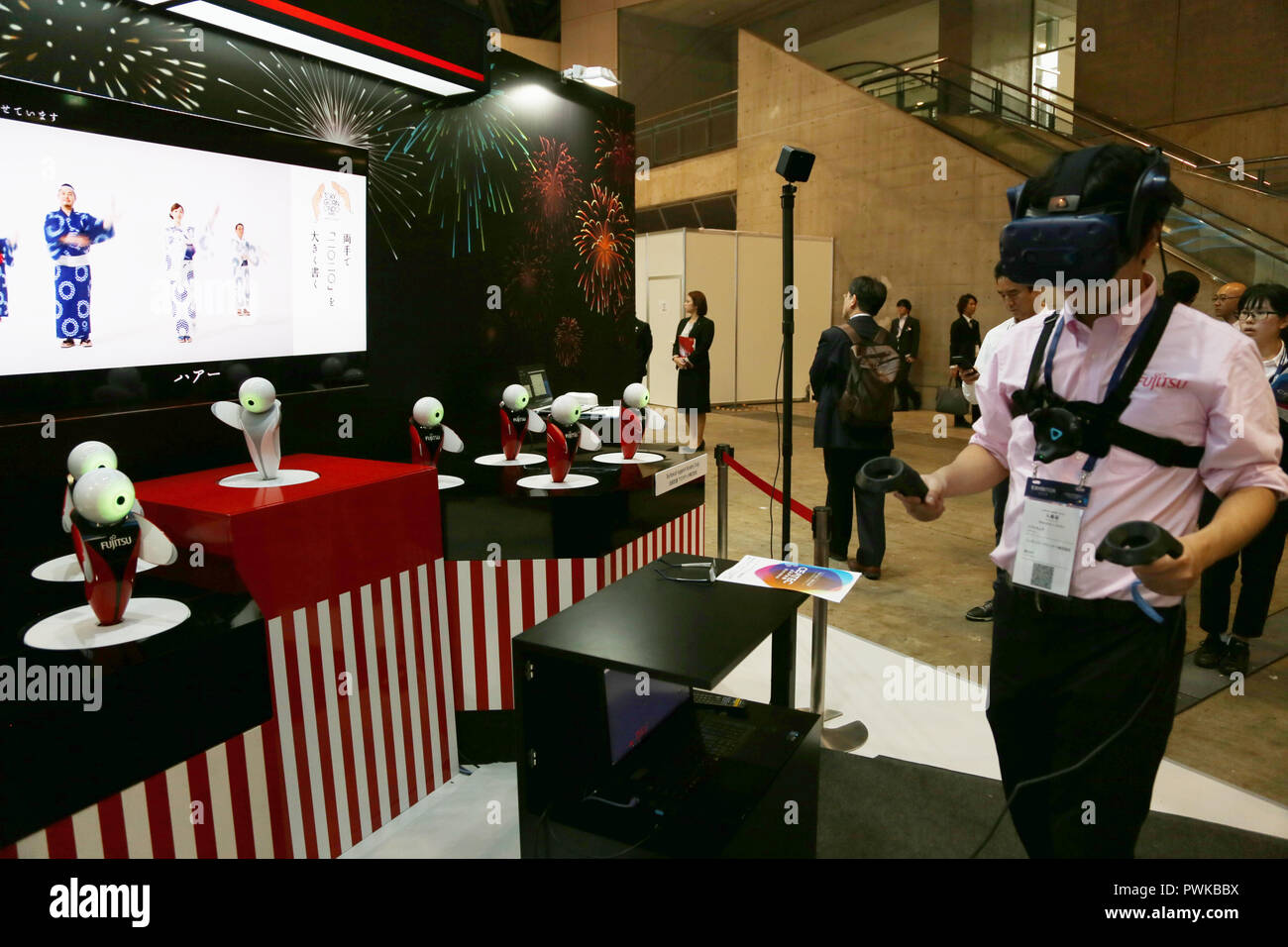 Chiba, Japan. 16th Oct, 2018. A staff of Fujitsu shows a wearable device at the CEATEC Japan 2018, or 'the Comprehensive Exhibition of Cutting-Edge IT and Electronics,' in Chiba, Japan, Oct. 16, 2018. This year's Japan high-tech fair CEATEC opened on Tuesday. Credit: Qian Zheng/Xinhua/Alamy Live News Stock Photo