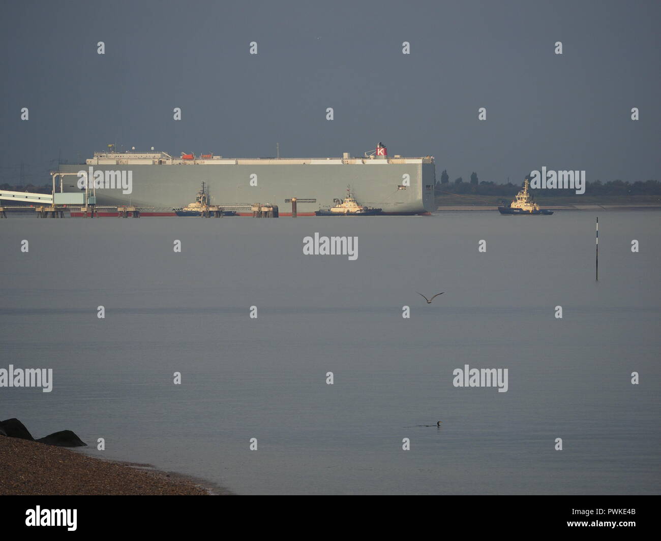 Sheerness, Kent, UK. 17th Oct, 2018. UK Weather: sunny spells with dark skies in the distance in Sheerness, Kent this morning.  Three tugs help berth vehicles carrier 'Aegean Highway'. Credit: James Bell/Alamy Live News Stock Photo