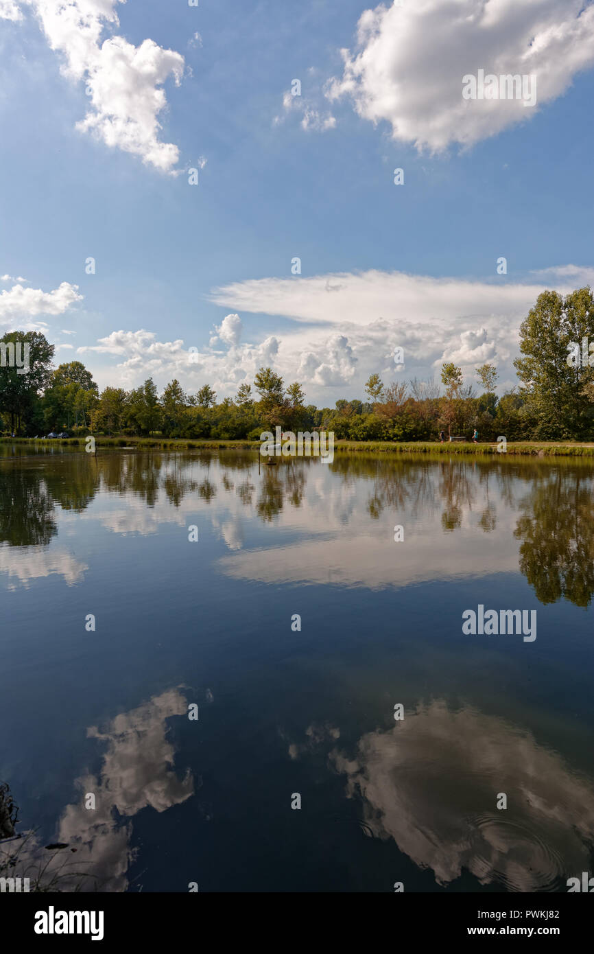 Little lake with reflections, clouds and blue sky Stock Photo