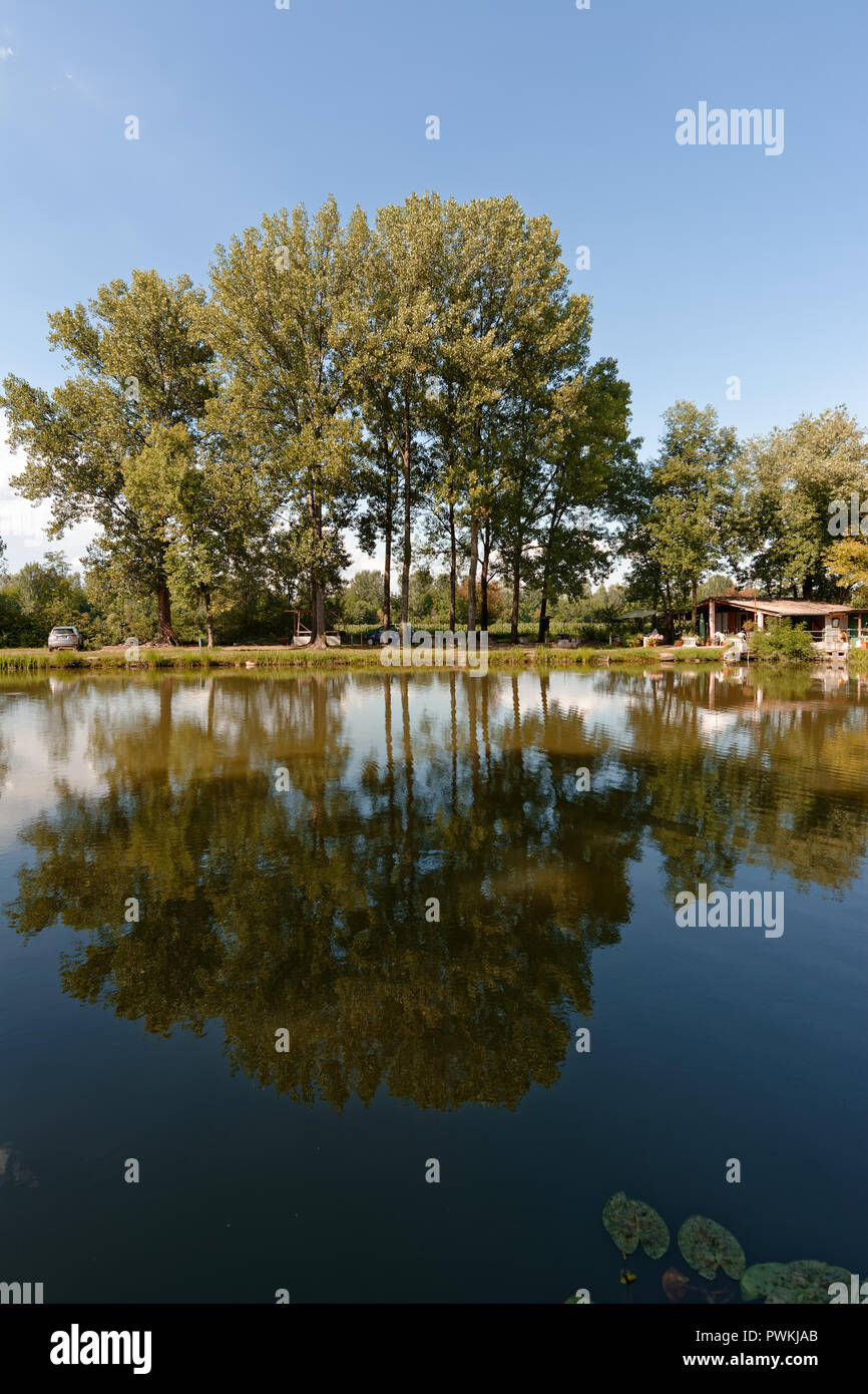 Mirroring in a lake with a hut in the background Stock Photo
