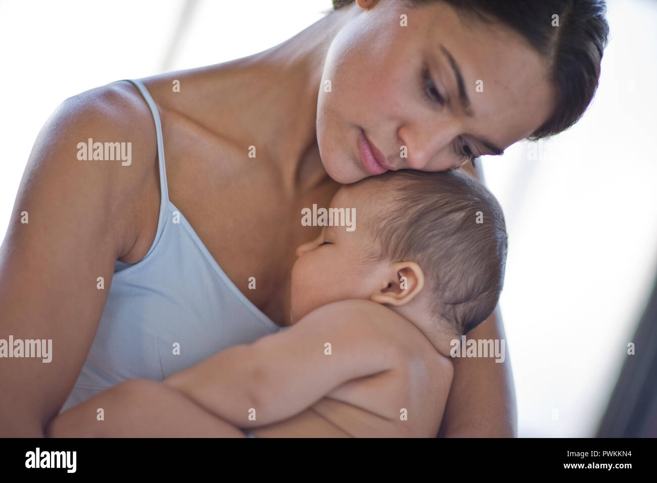 Contemplative young woman holding her baby. Stock Photo